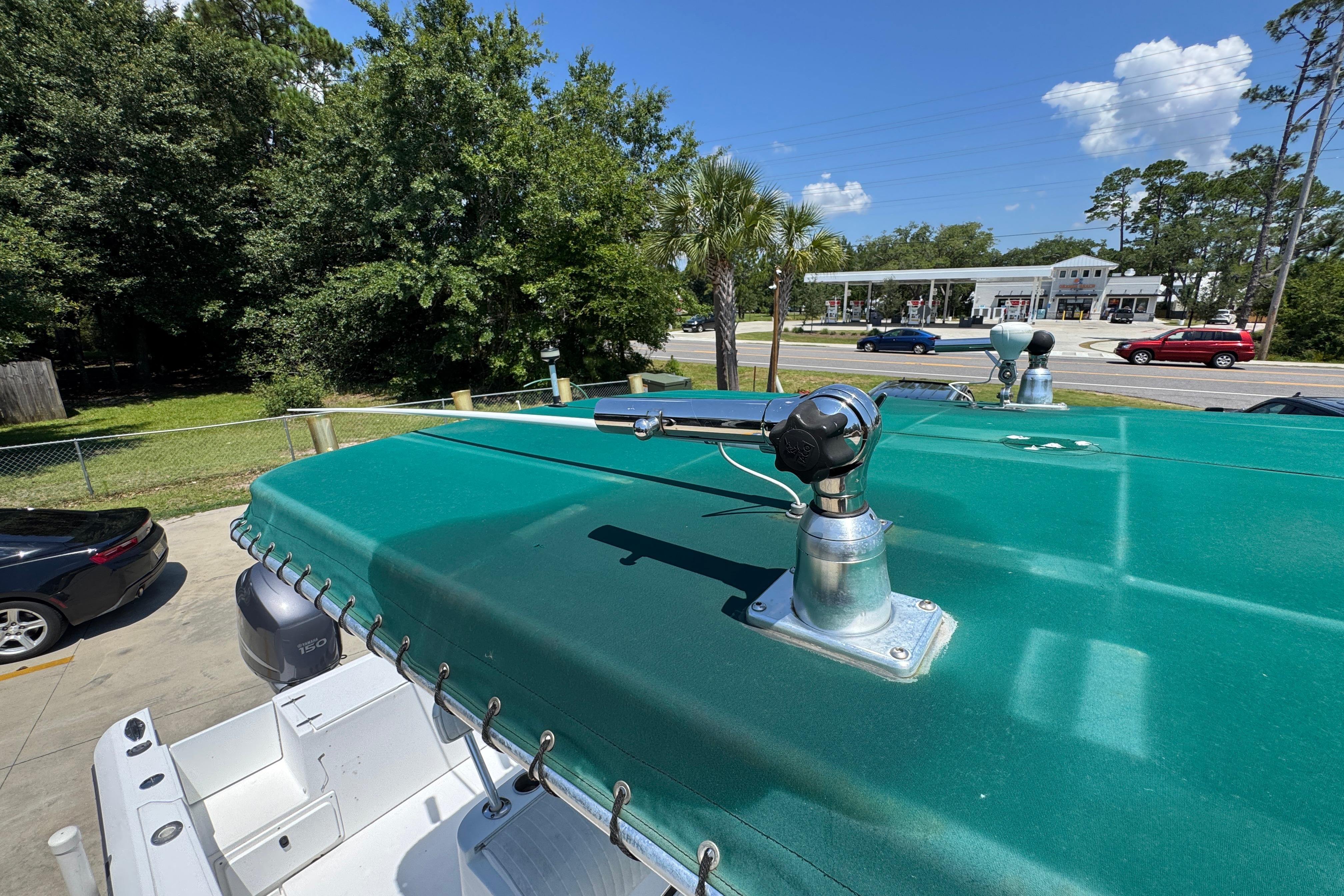 2000 Stamas 250 Tarpon boat with green canopy and mounted equipment, parked outdoors.