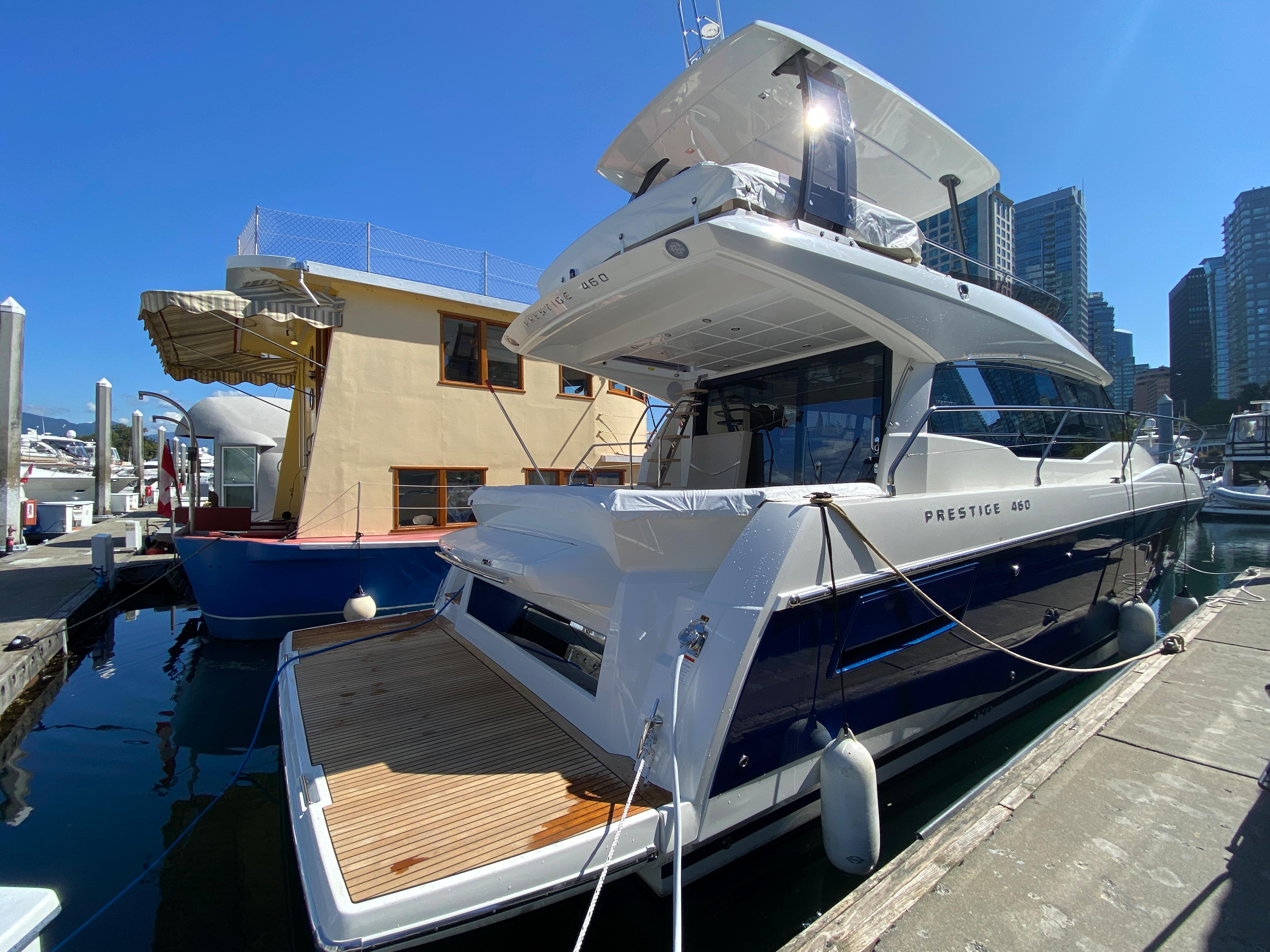 2022 Prestige 460 yacht docked at marina under clear blue sky.