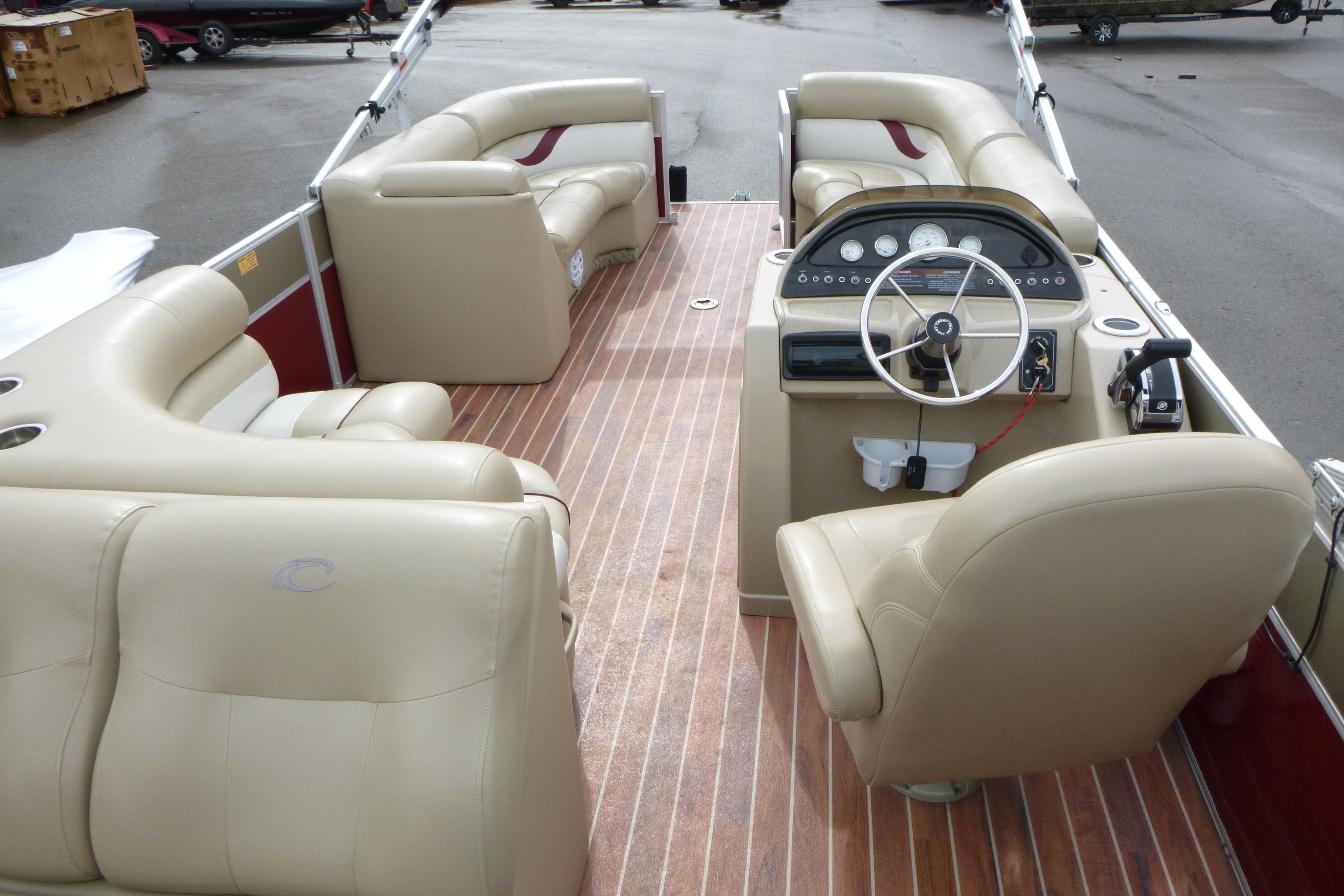 Interior of a 2012 Crest 230SLR Classic pontoon boat with beige seating and wood flooring.