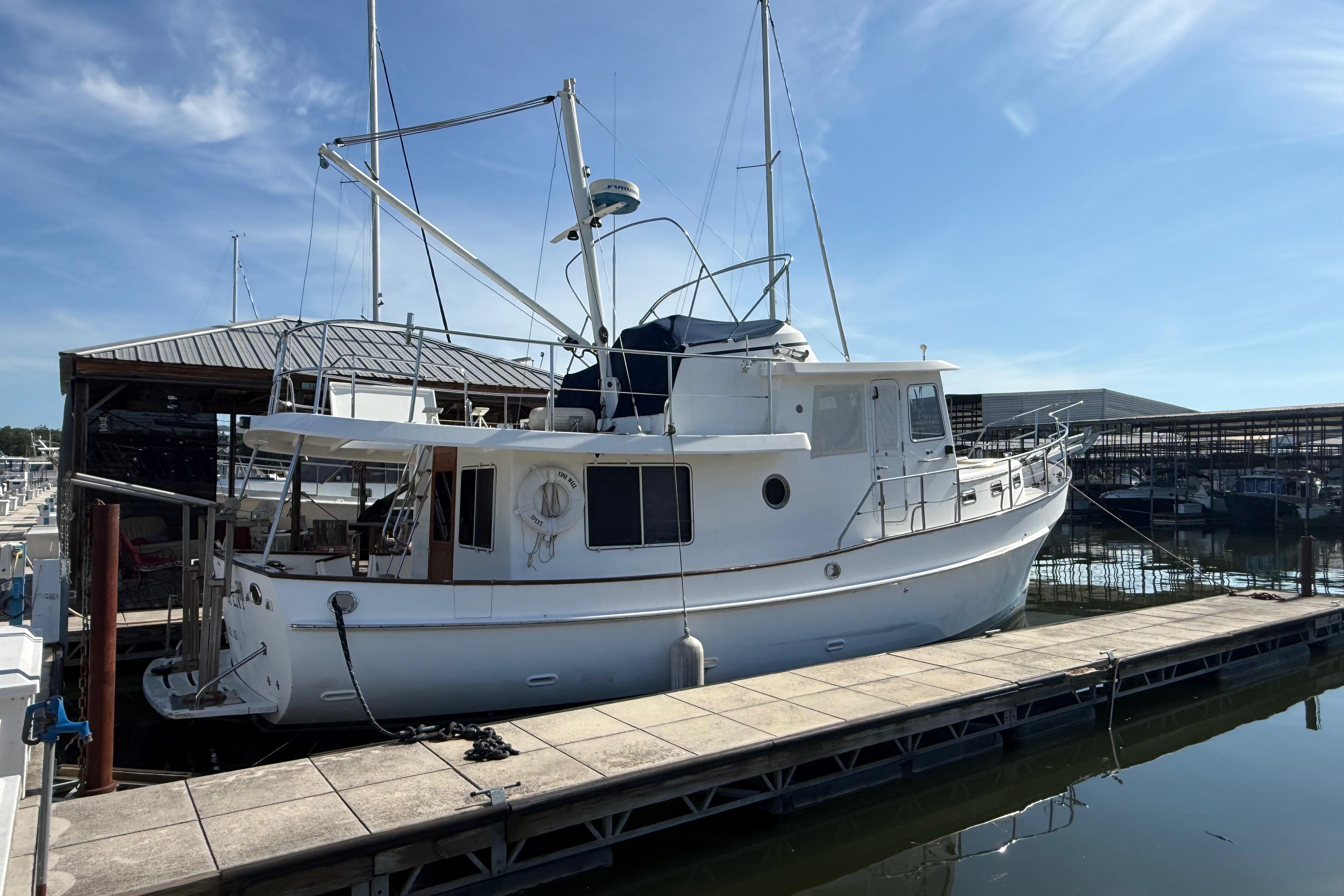 2001 Kadey-Krogen 39 yacht docked at a marina under a clear blue sky.