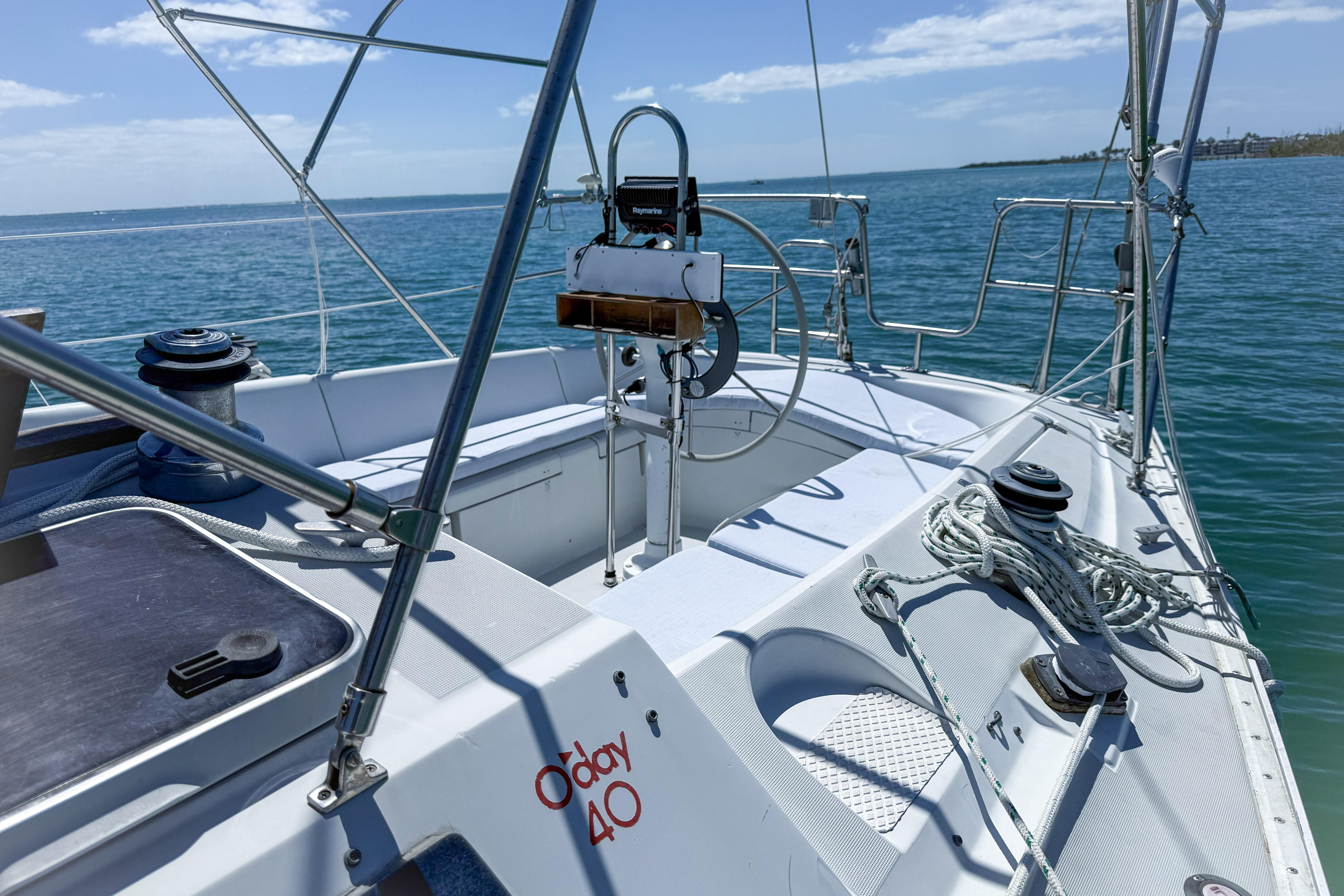 1988 Oday 40 sailboat cockpit with steering wheel, ropes, and winches on a sunny day.