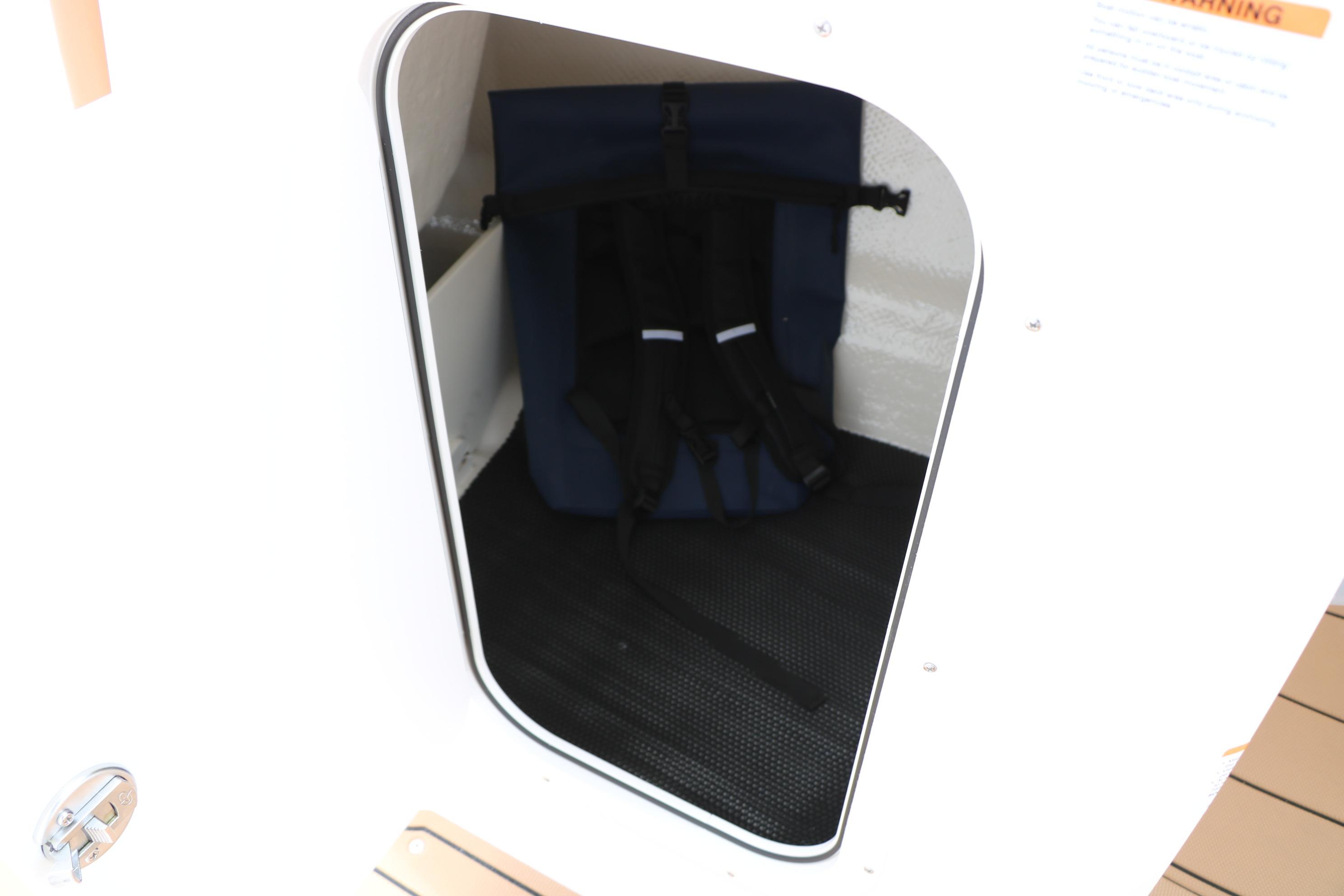 Storage compartment inside 2025 Chaparral 23 SSi boat, featuring safety equipment.