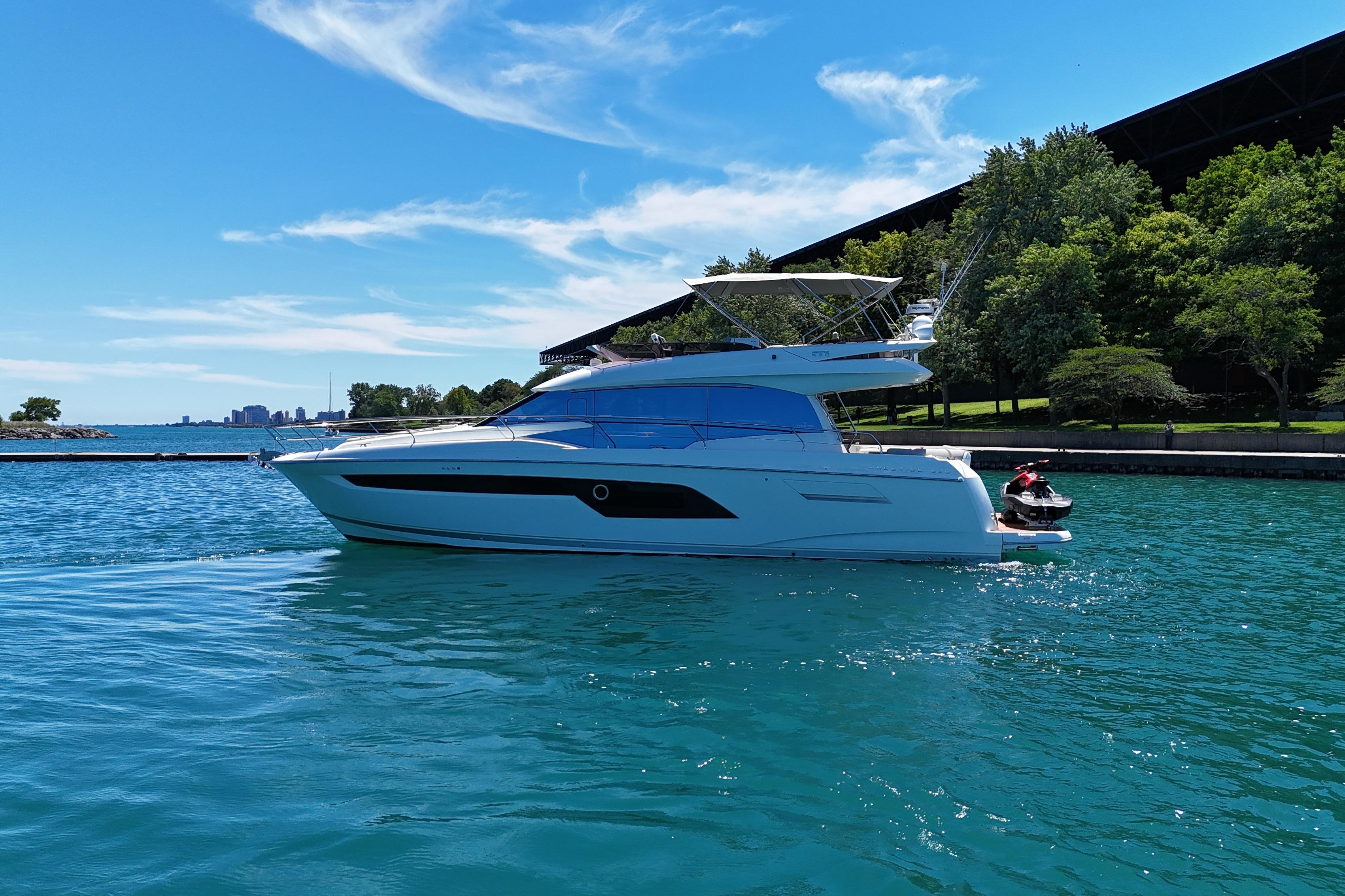 Luxury 2022 Prestige 520 yacht cruising on clear blue water under a sunny sky.