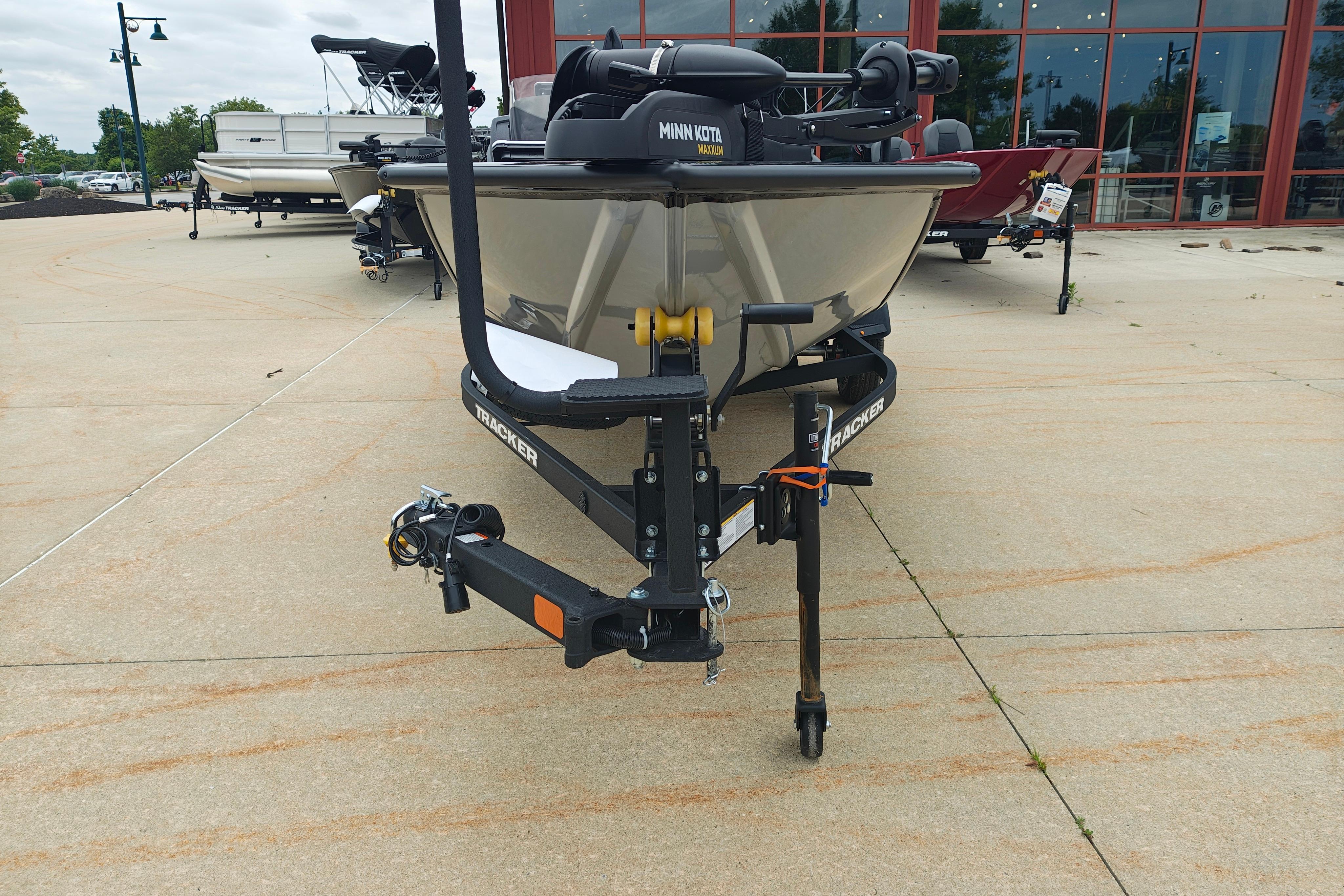 2026 Tracker Pro Team 175 boat on trailer, displayed outdoors near a showroom.