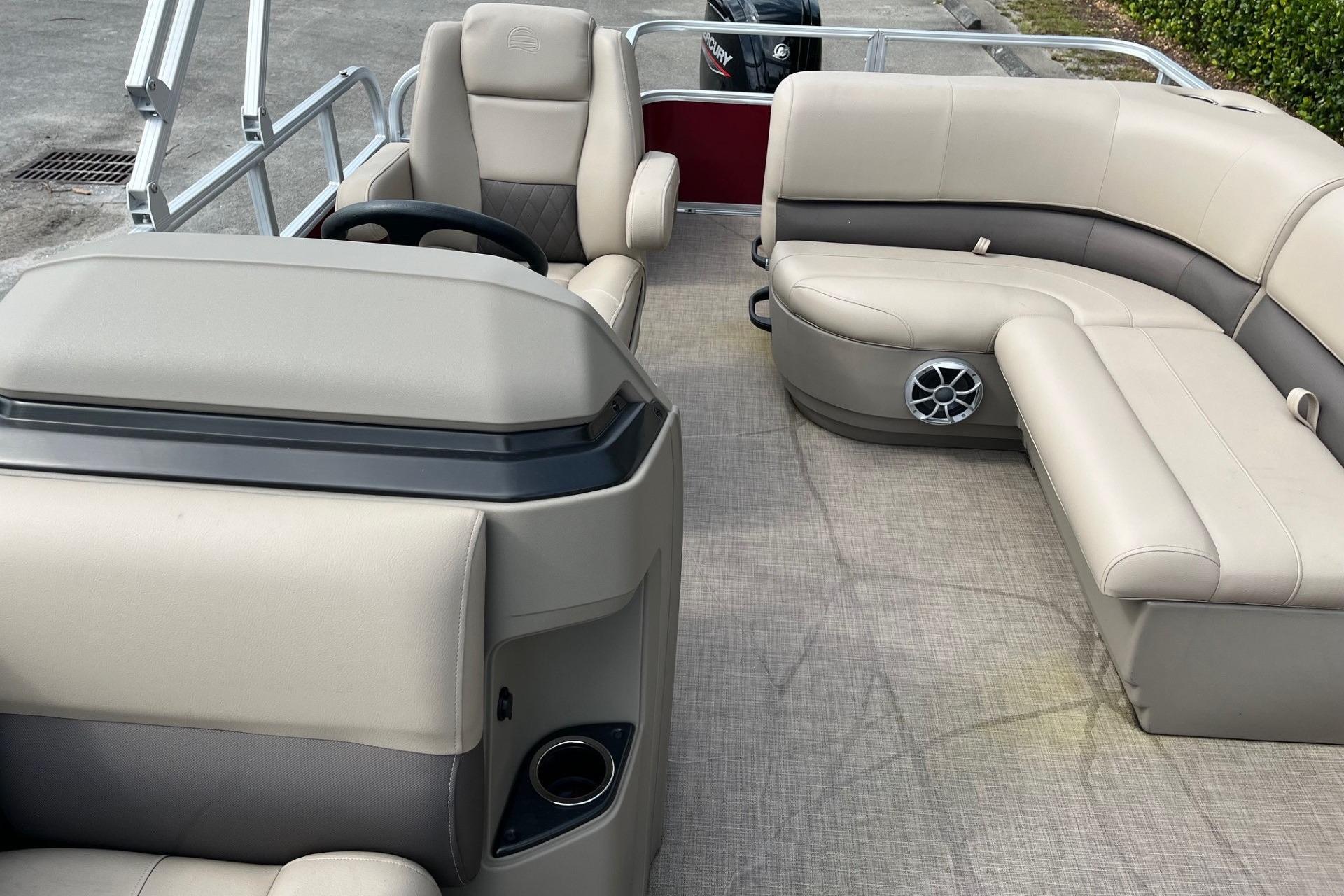 2025 Sun Tracker Party Barge 18 DLX interior with beige seating and steering console.