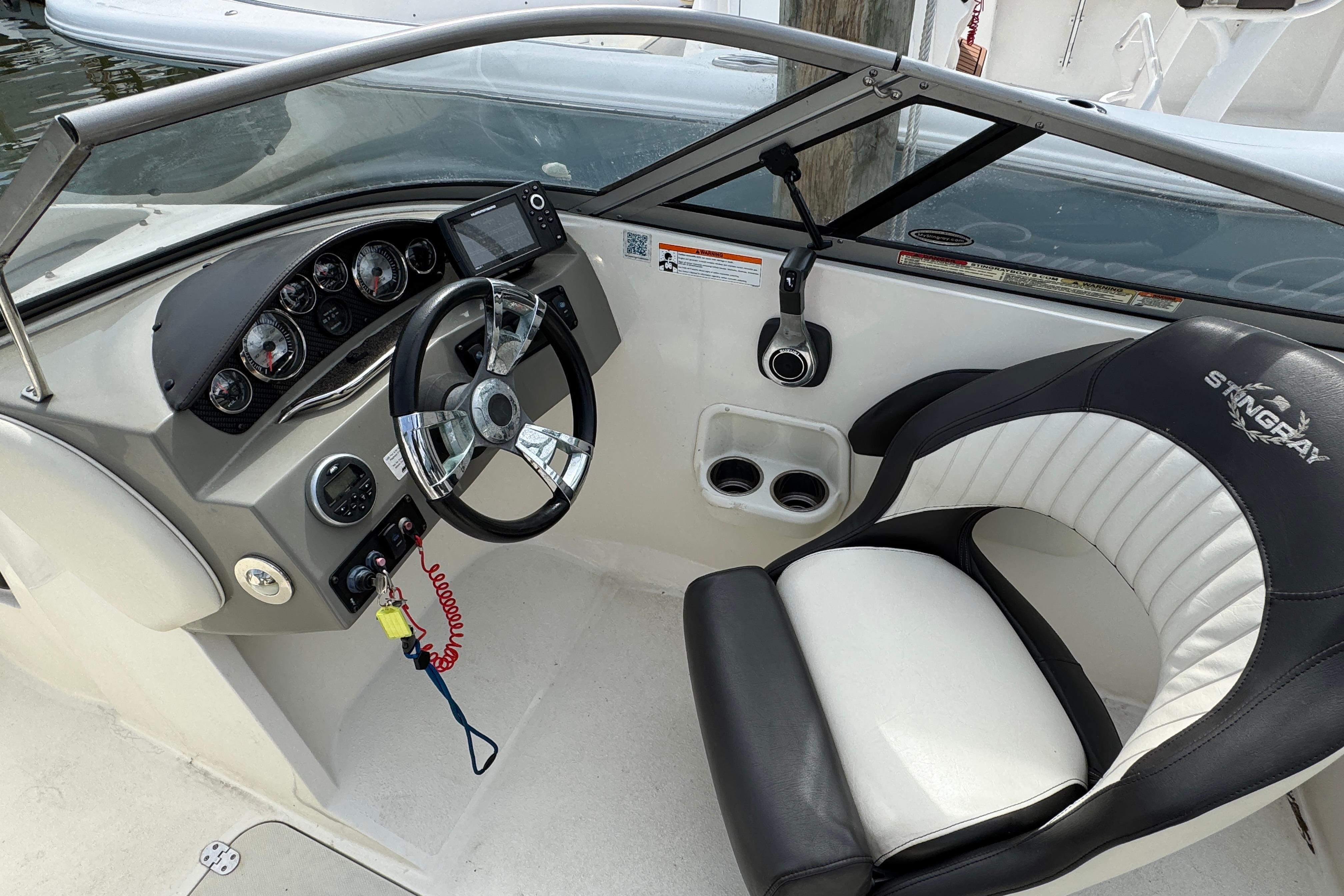 2018 Stingray 204 LR boat cockpit with steering wheel and comfortable seating.