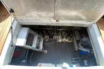 Engine compartment of a 1982 C @ L Sea Ranger boat, showing equipment and storage space.