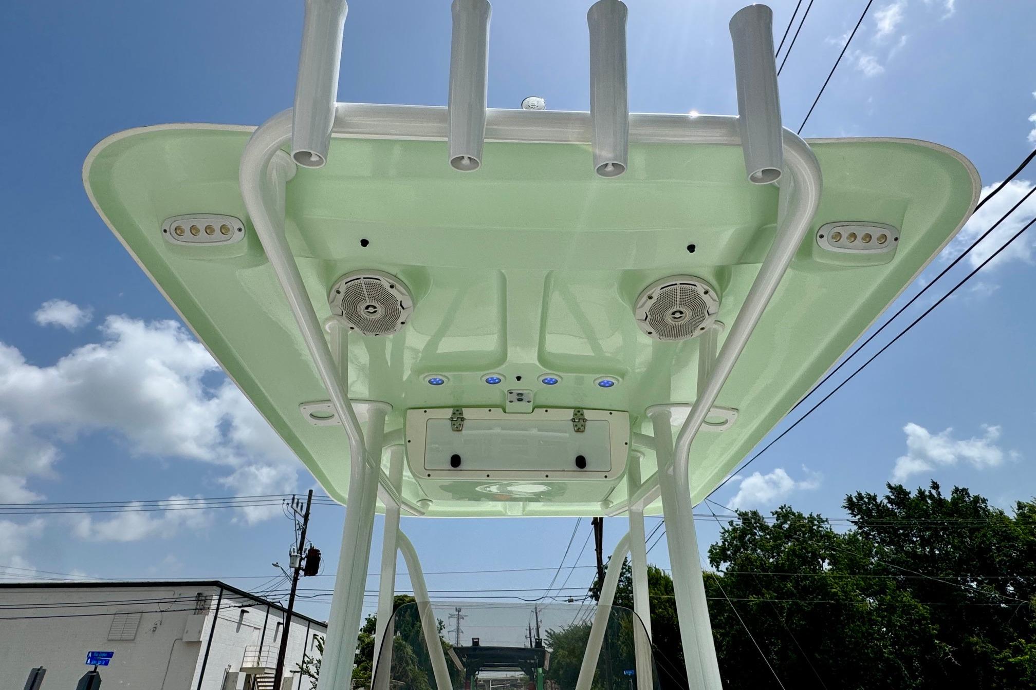 2015 Sea Hunt Ultra 234 T-top with speakers and rod holders under clear sky.