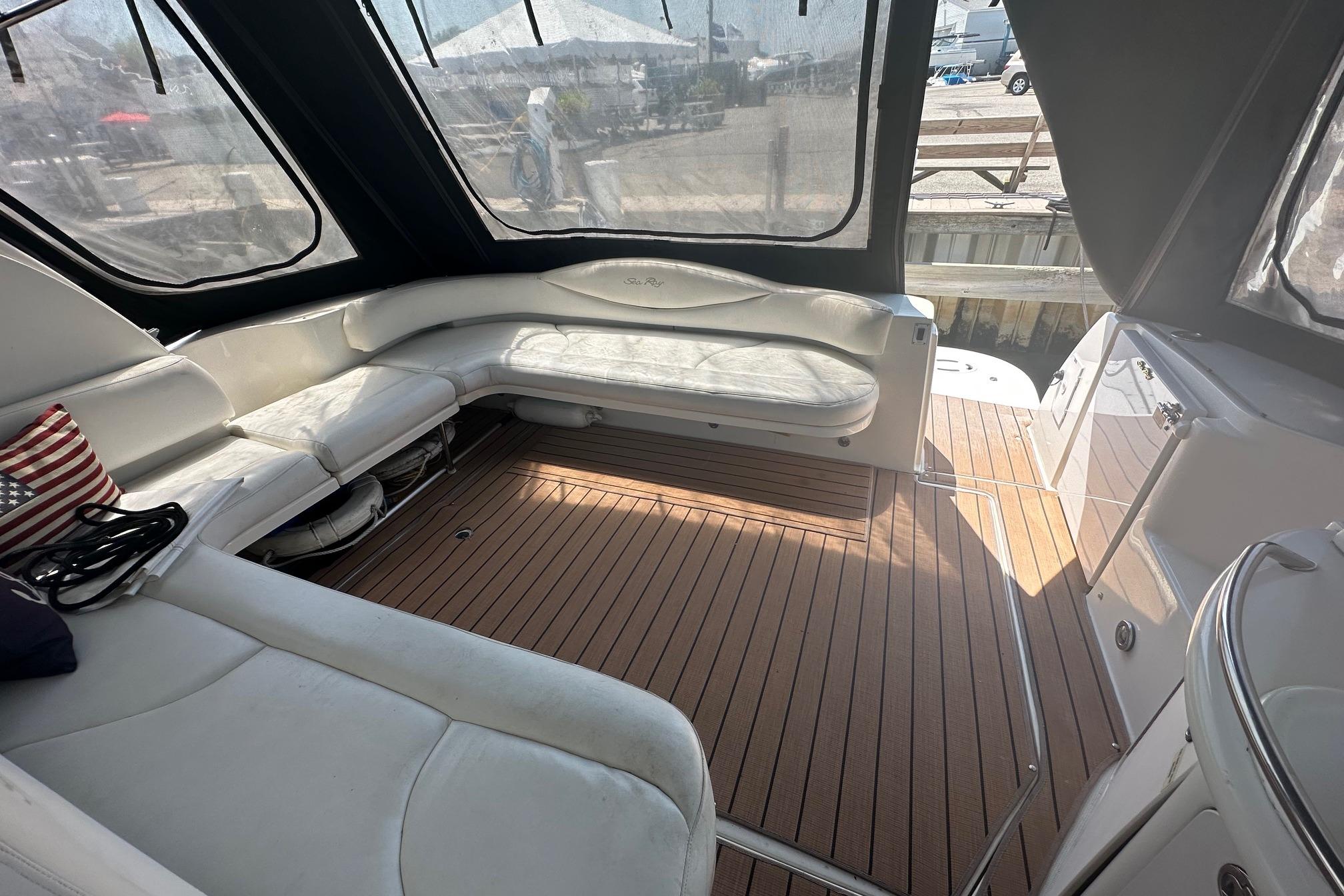 Luxurious 2001 Sea Ray 410 Sundancer yacht interior with white seating and wooden flooring.