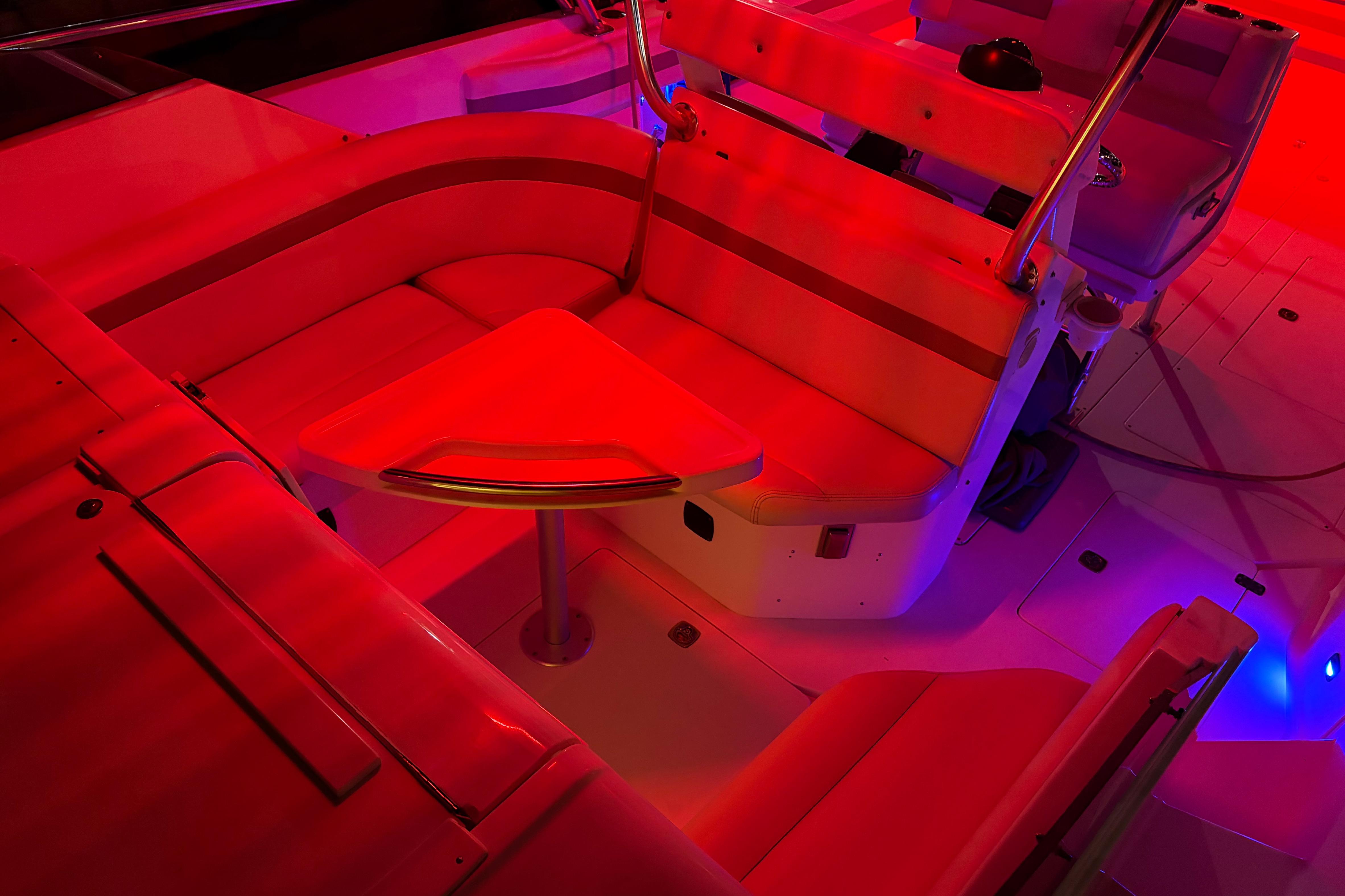 1998 Intrepid 339 Walkaround boat interior with red ambient lighting and seating area.