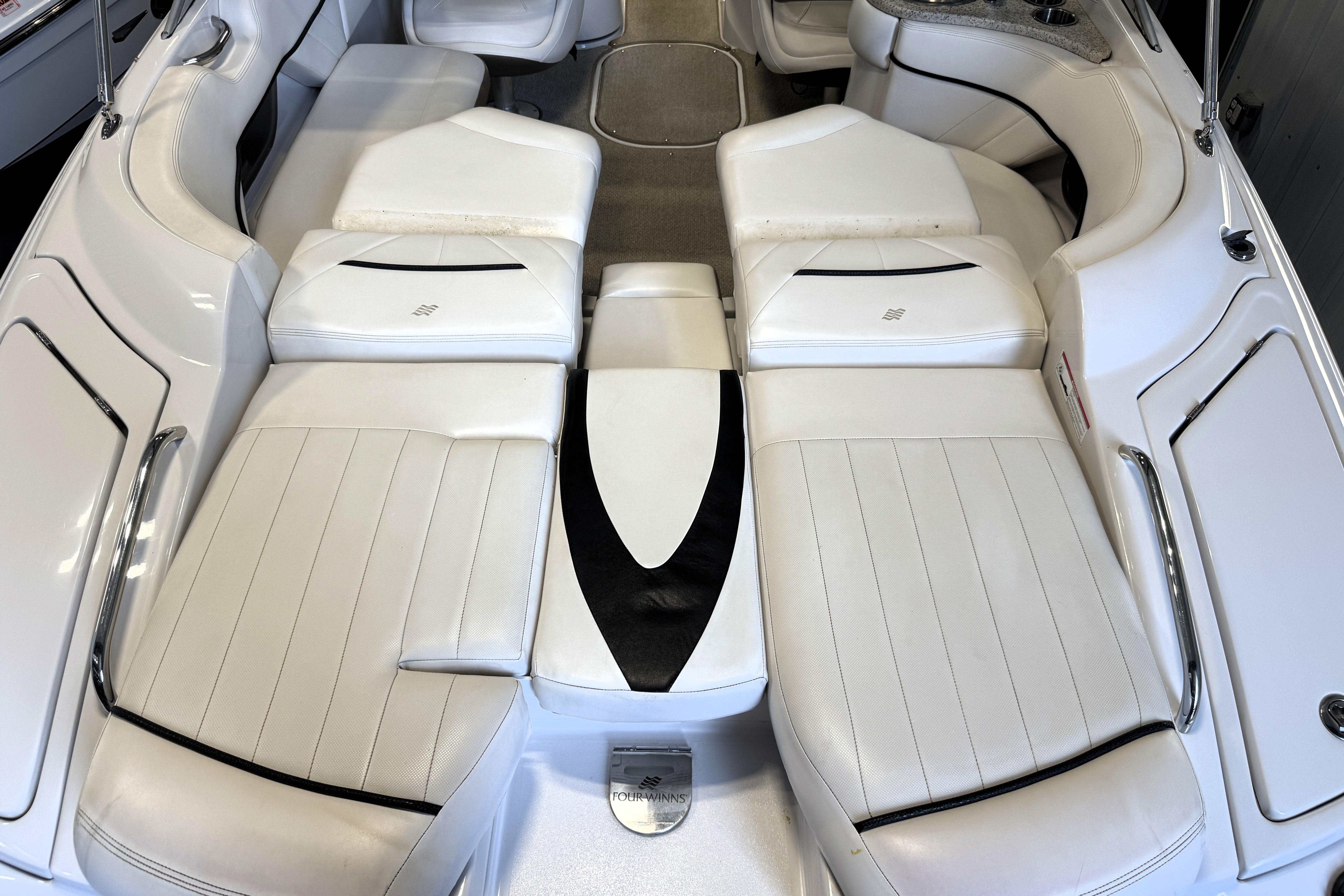 Interior of 2008 Four Winns H240 boat with white leather seating.