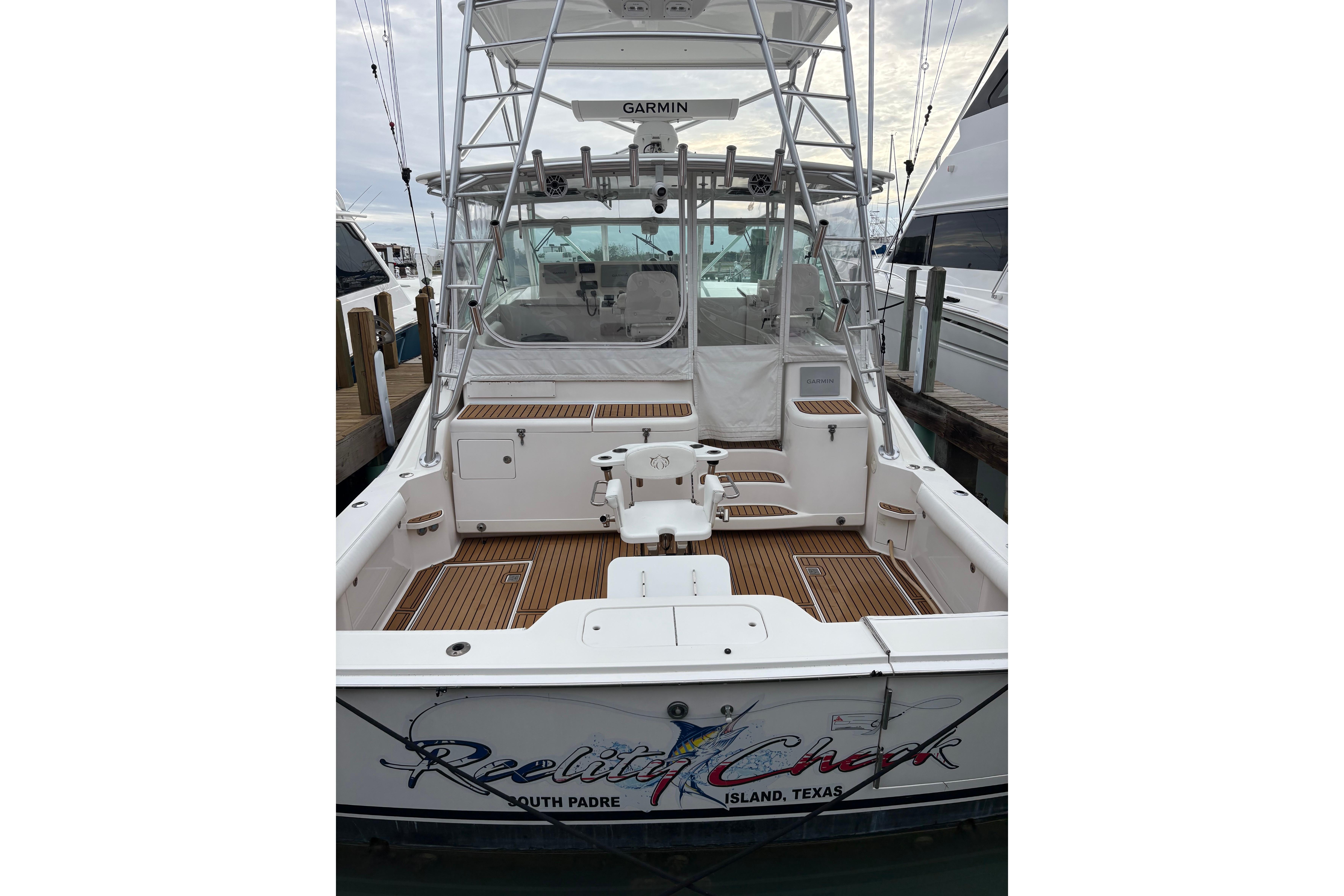 2004 Cabo 40 Hardtop Express boat docked, featuring spacious deck and fishing equipment.