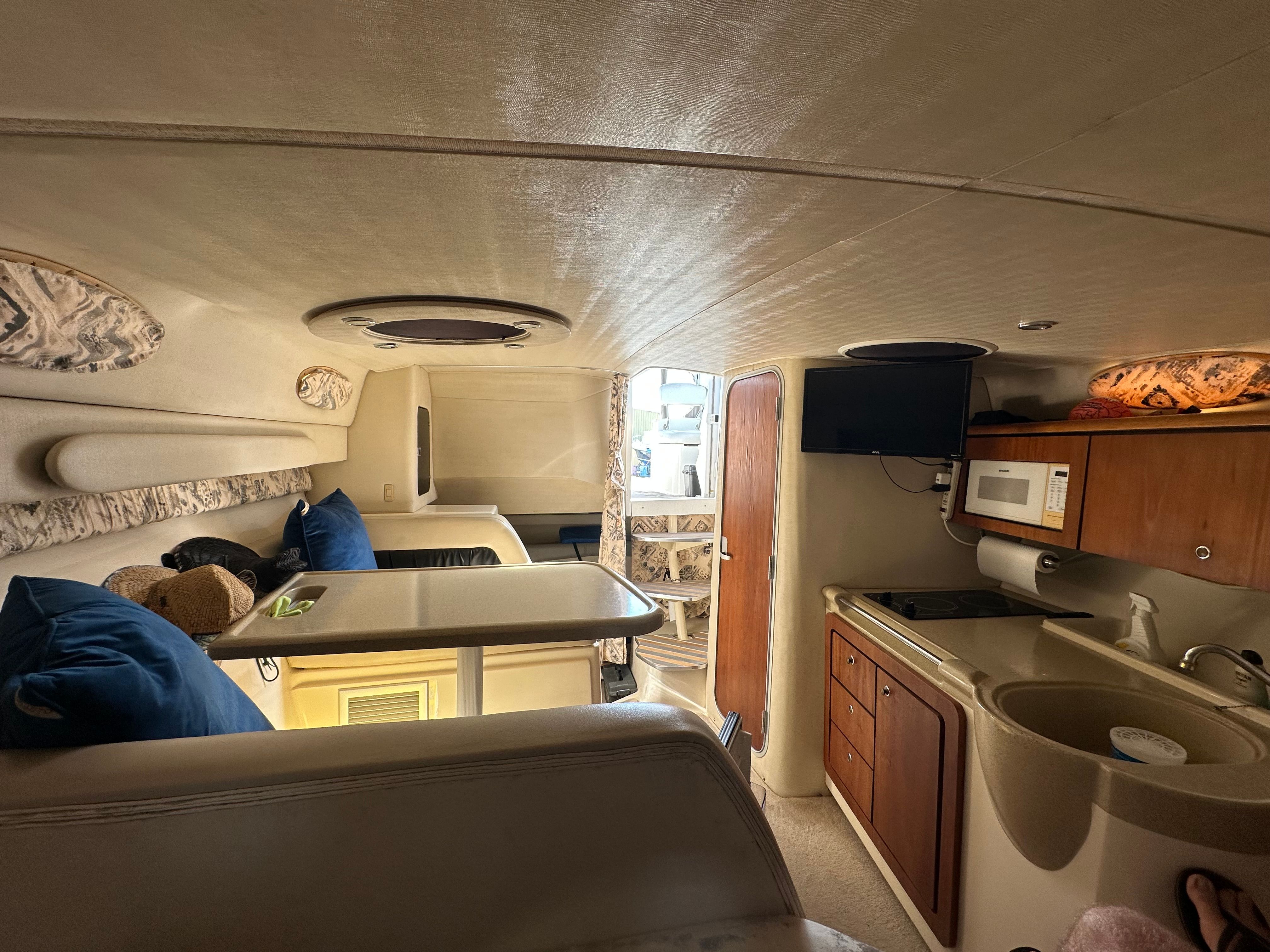 Interior of 1999 Wellcraft 3000 Martinique with kitchen and seating area.