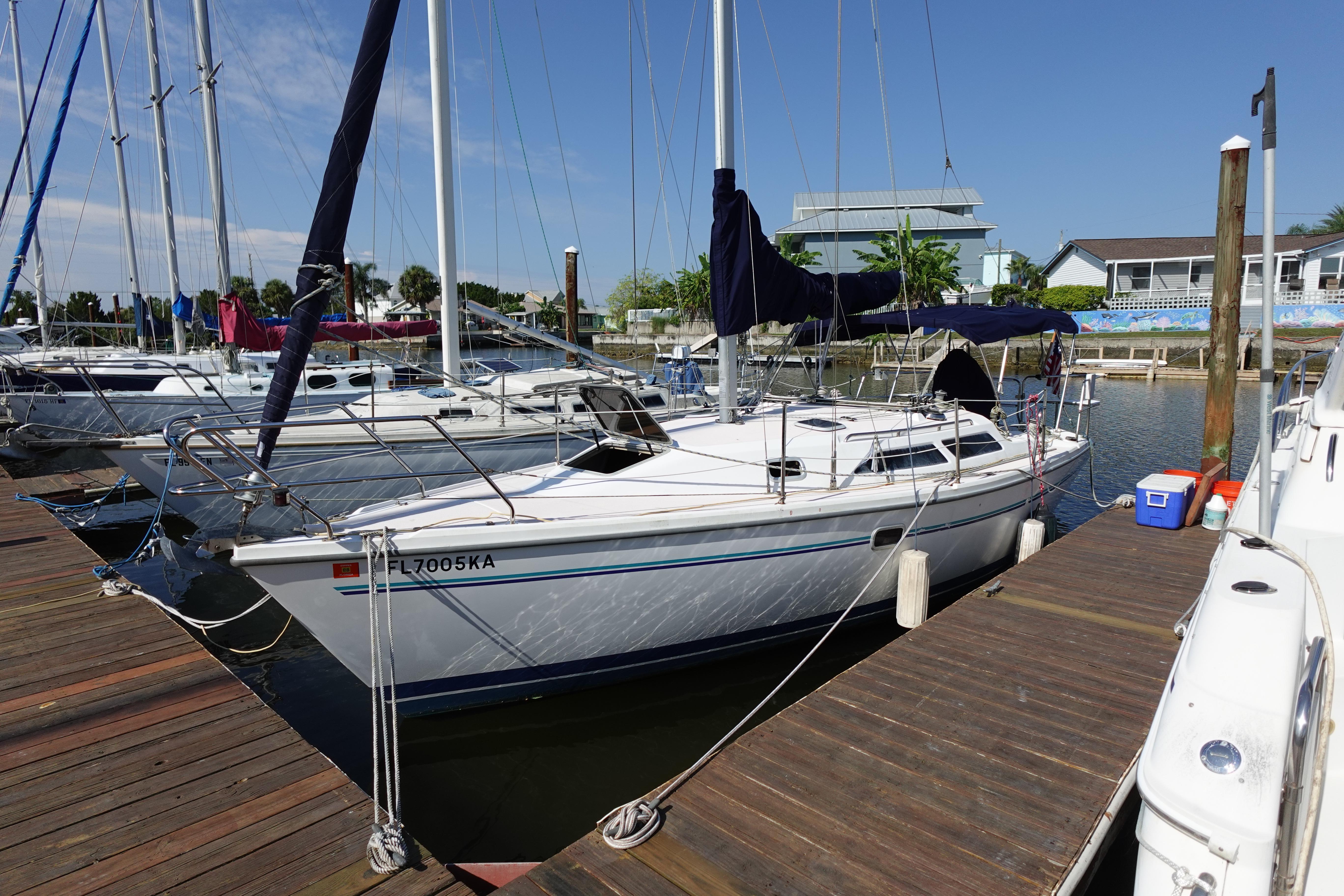 1997 Catalina 28 sailboat docked at marina under clear blue sky.