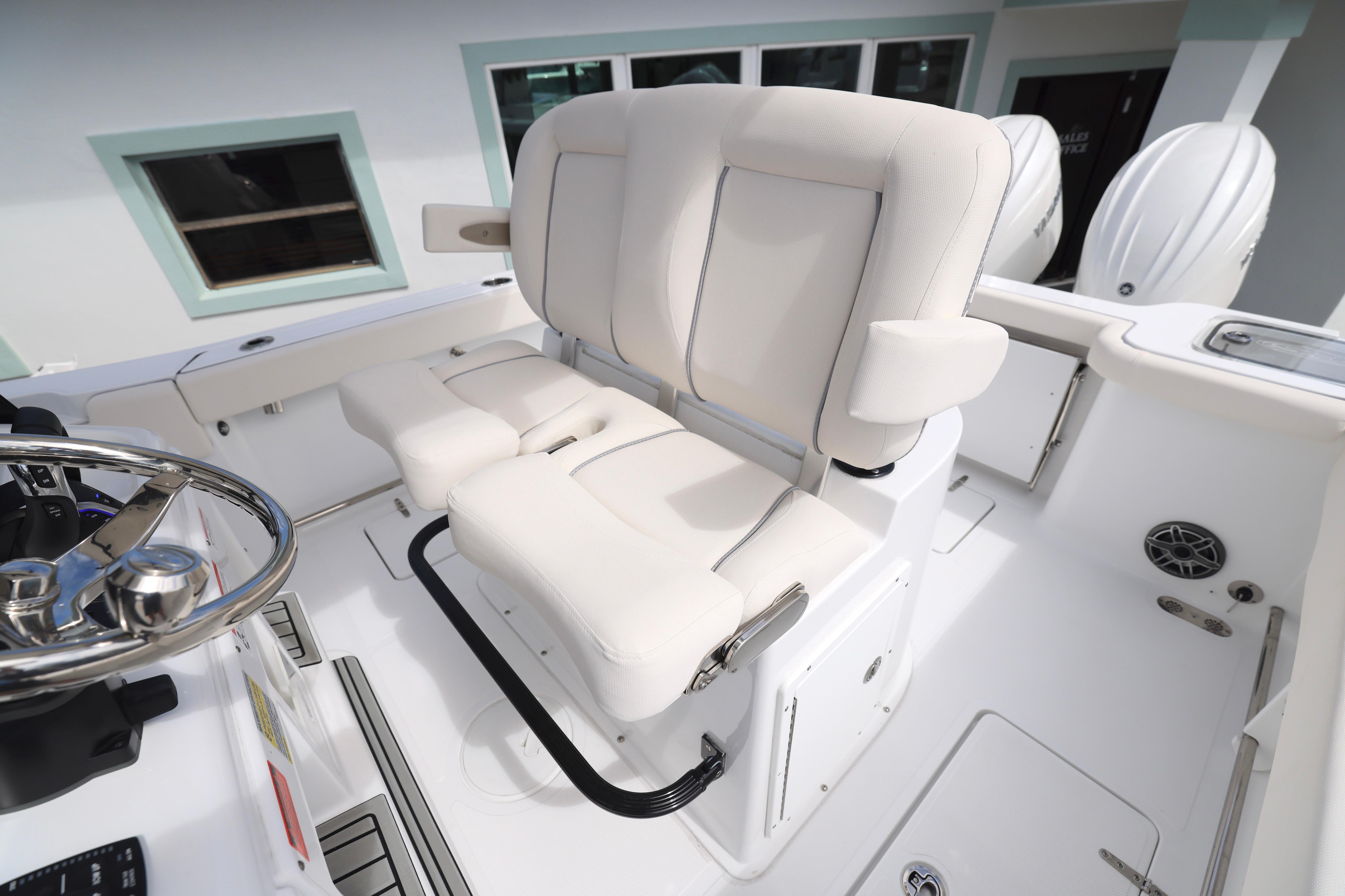 2026 Sea Hunt Gamefish 25 boat interior with white cushioned seating and steering wheel.