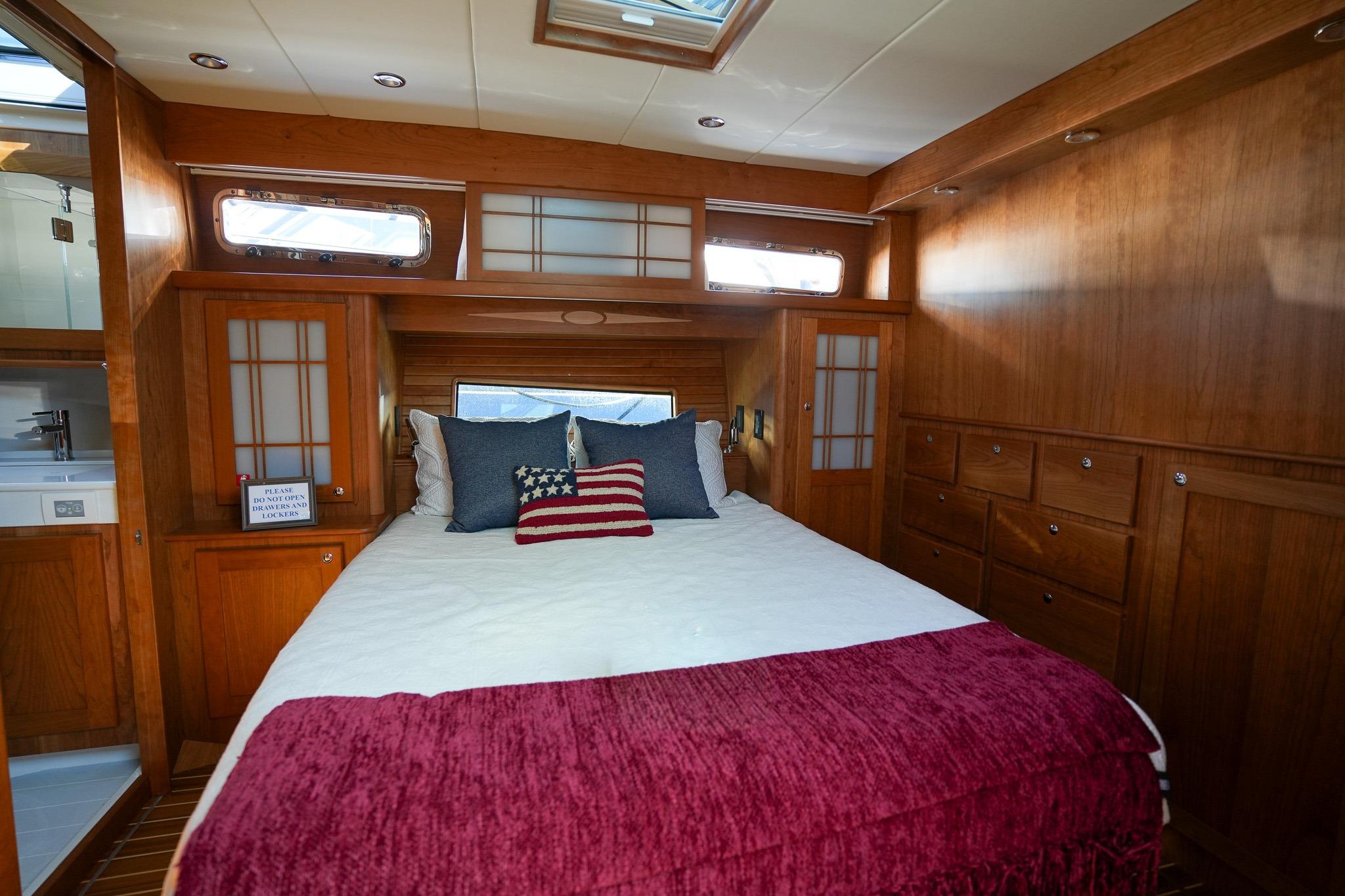 Luxurious bedroom interior of 2026 Sabre 51 Salon Express yacht with wooden cabinetry.