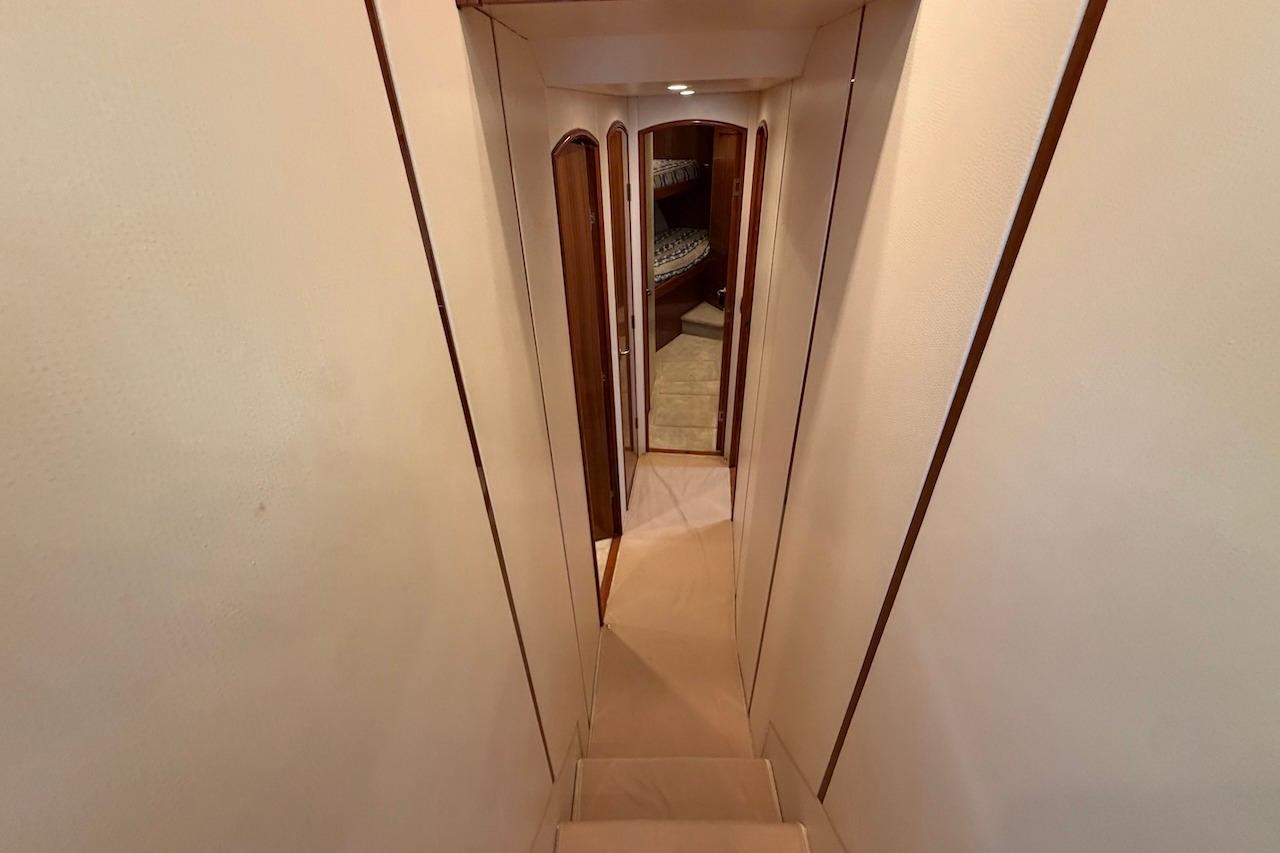 Interior hallway of 2012 Viking 50 Convertible yacht, featuring elegant wood accents.