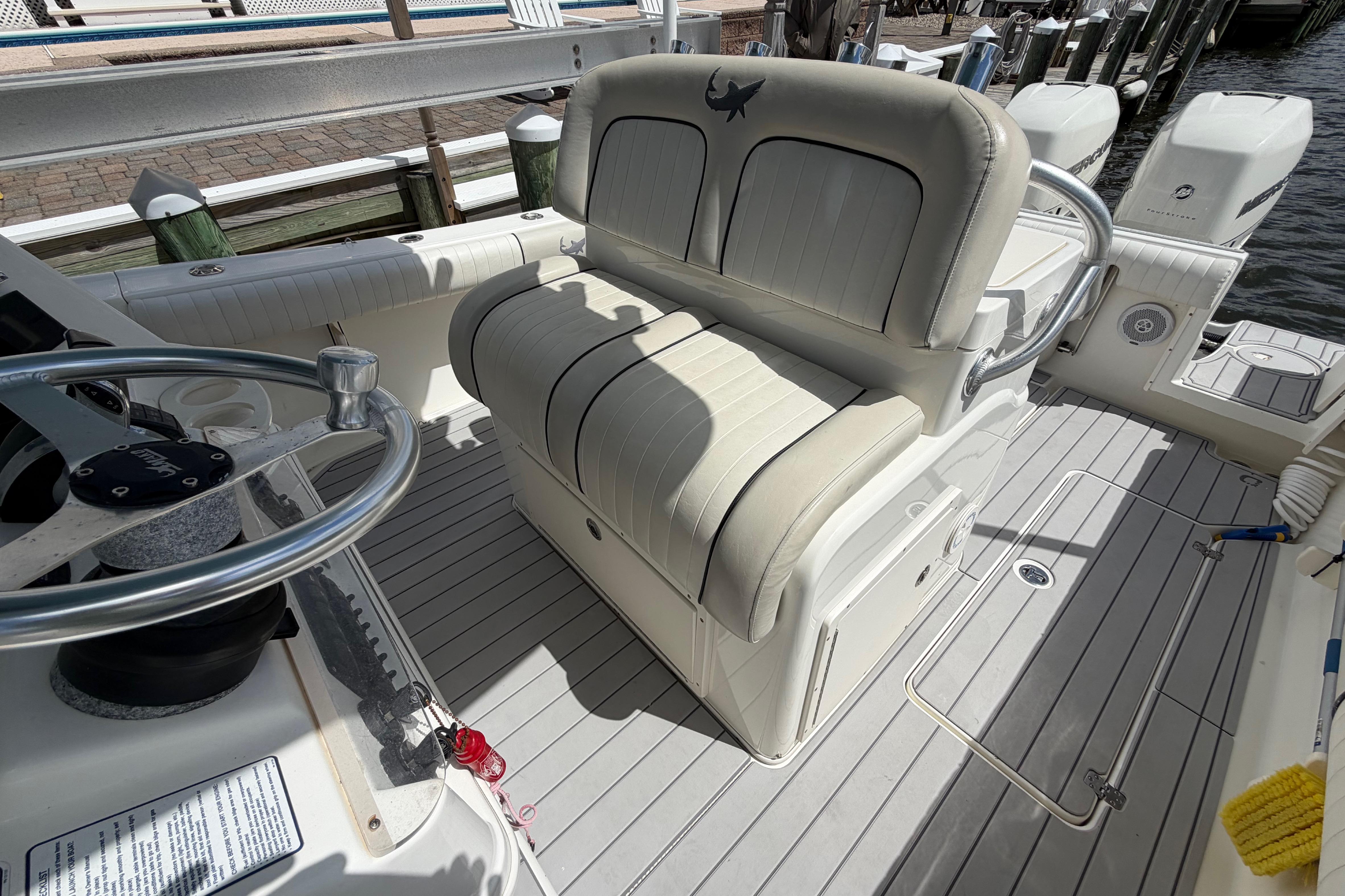 Interior of a 2017 Mako 284 Center Console boat with seating and steering wheel.