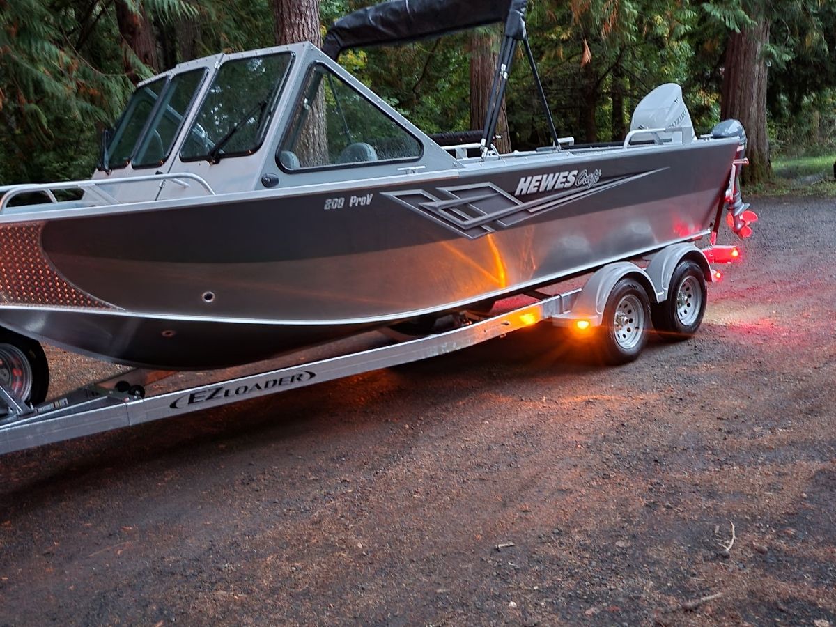 A 2021 Hewescraft Sea Pro 200 parked on a trailer in a wooded area.