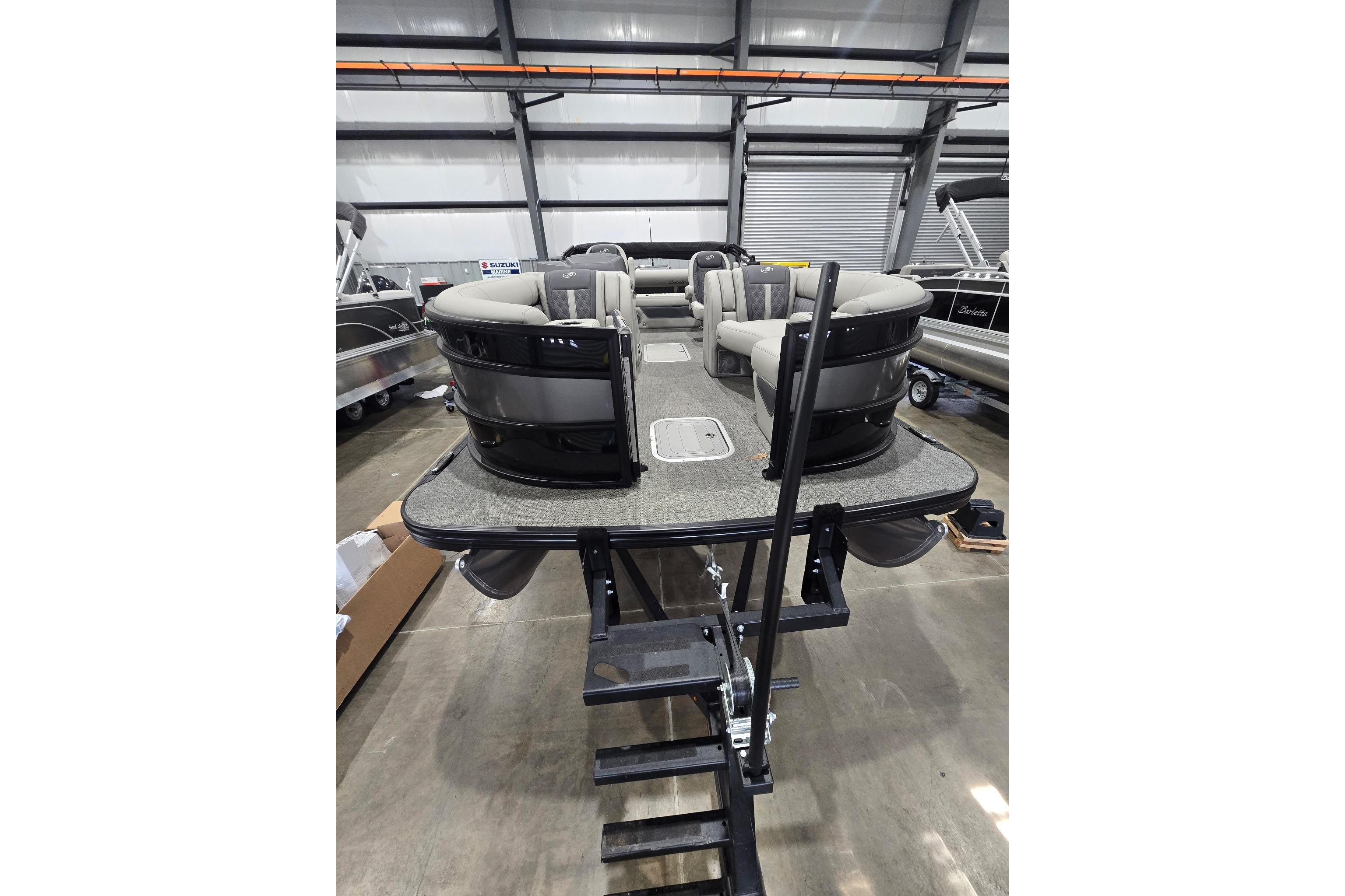 2025 Barletta Lusso 23UC pontoon boat in showroom, featuring luxurious seating and modern design.