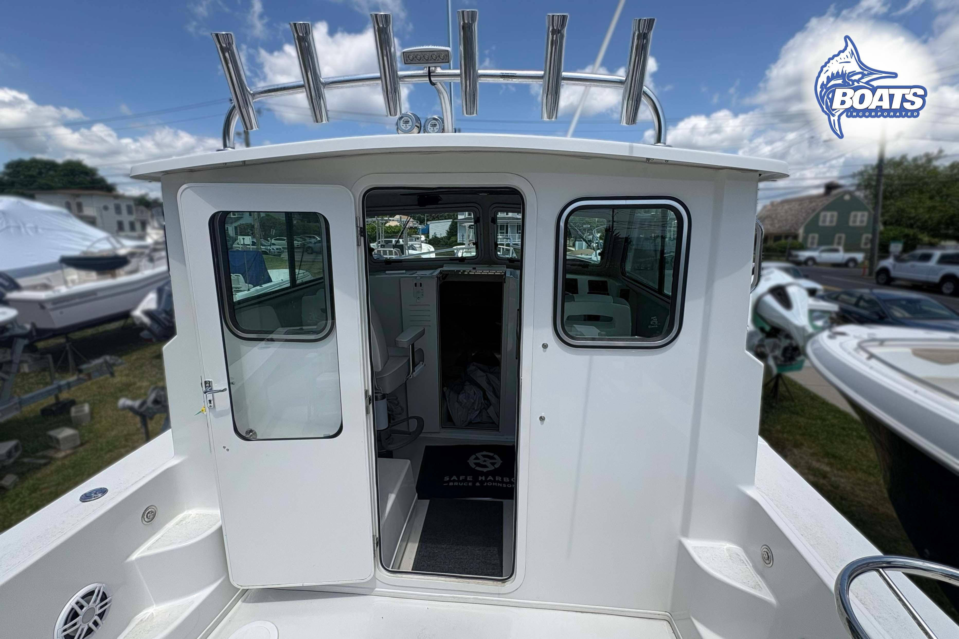 2021 Parker 2520 XLD Sport Cabin boat with open cabin door, docked outdoors.