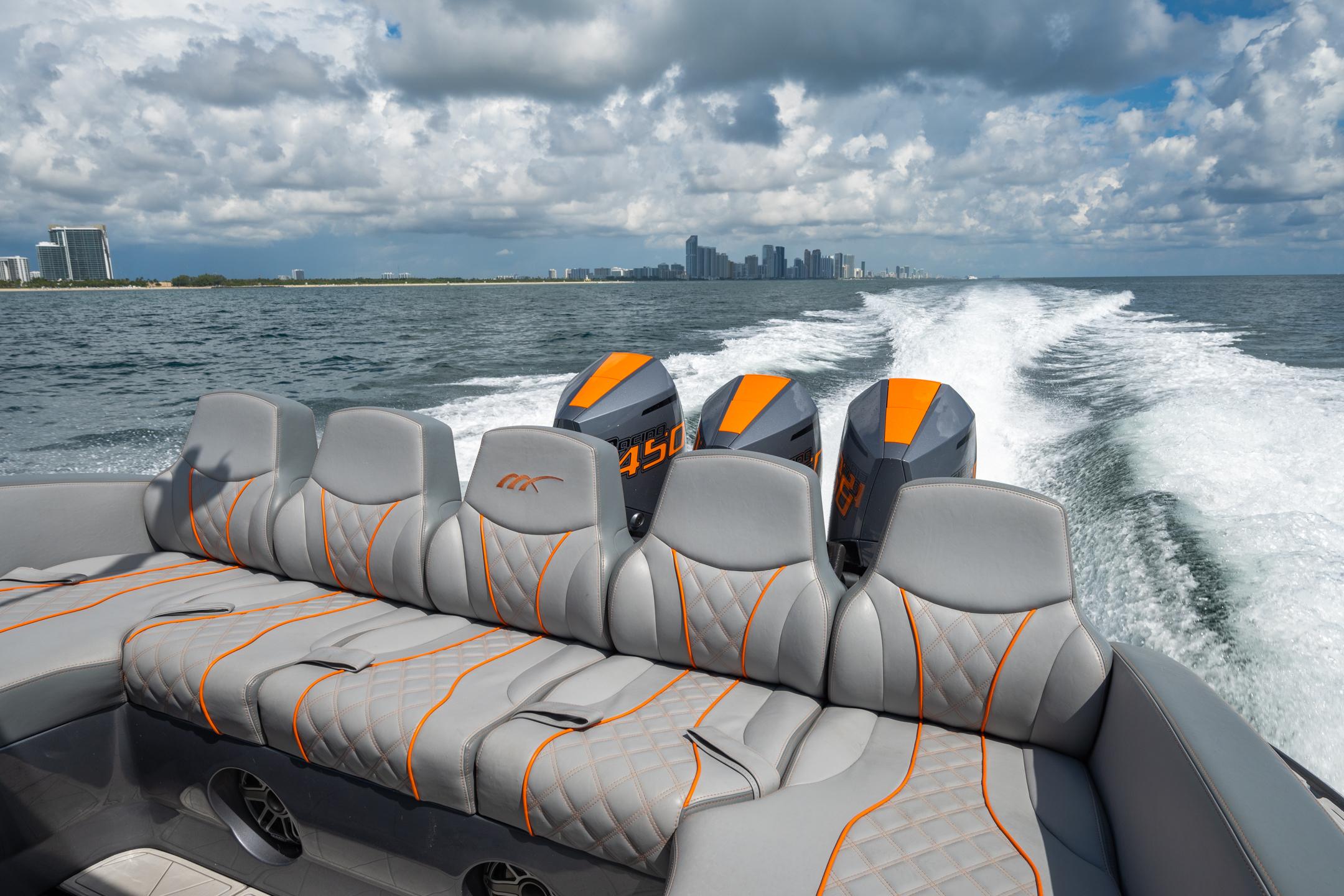 2022 Midnight Express 37' Open boat cruising with powerful engines, city skyline in background.