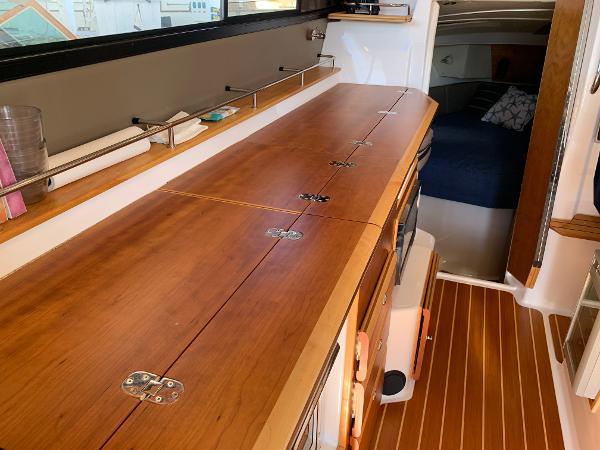 2021 Cutwater C-32 CB interior with wooden cabinetry and cozy sleeping area.