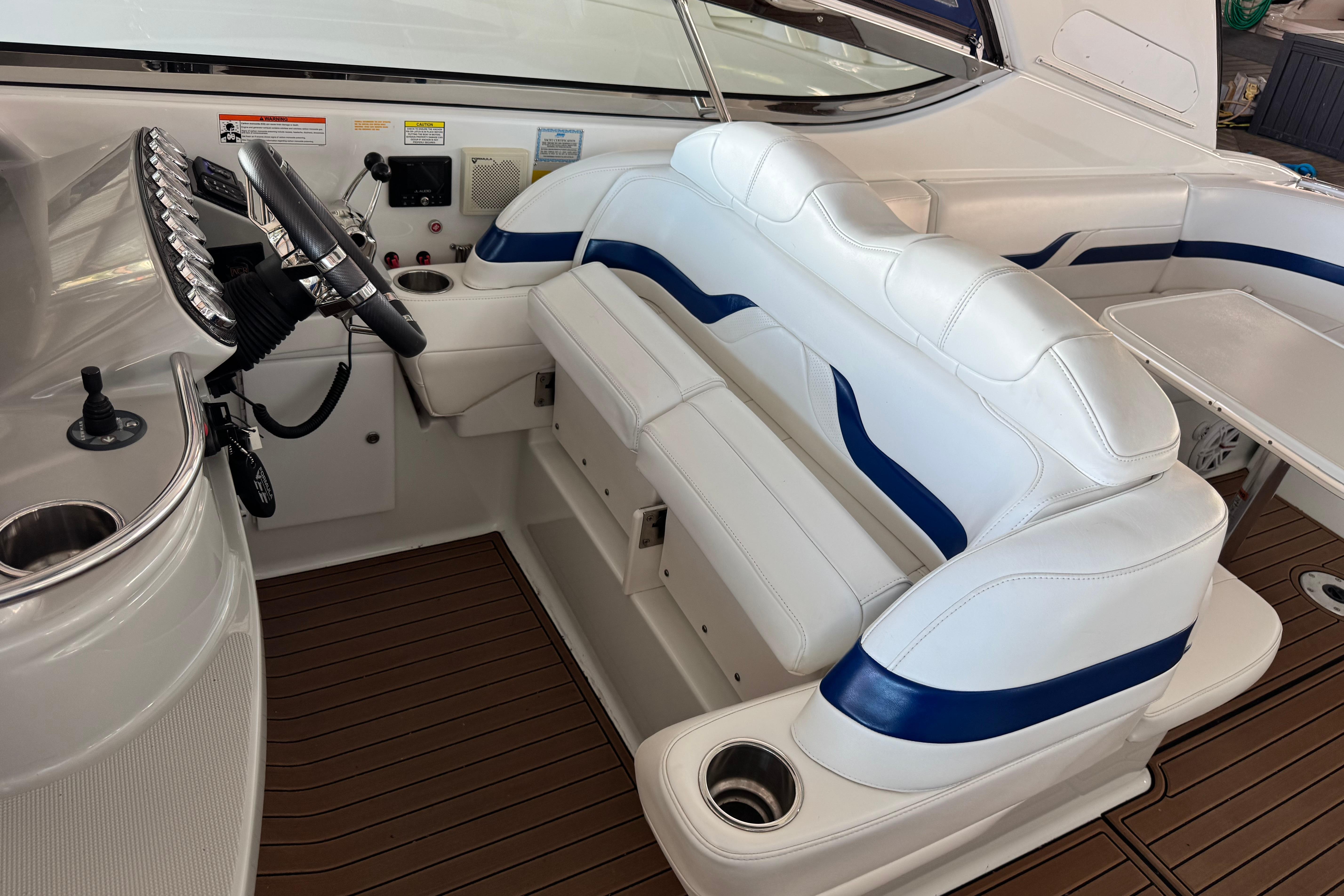 2008 Formula 400 Super Sport boat interior with white and blue seating, steering wheel, and controls.