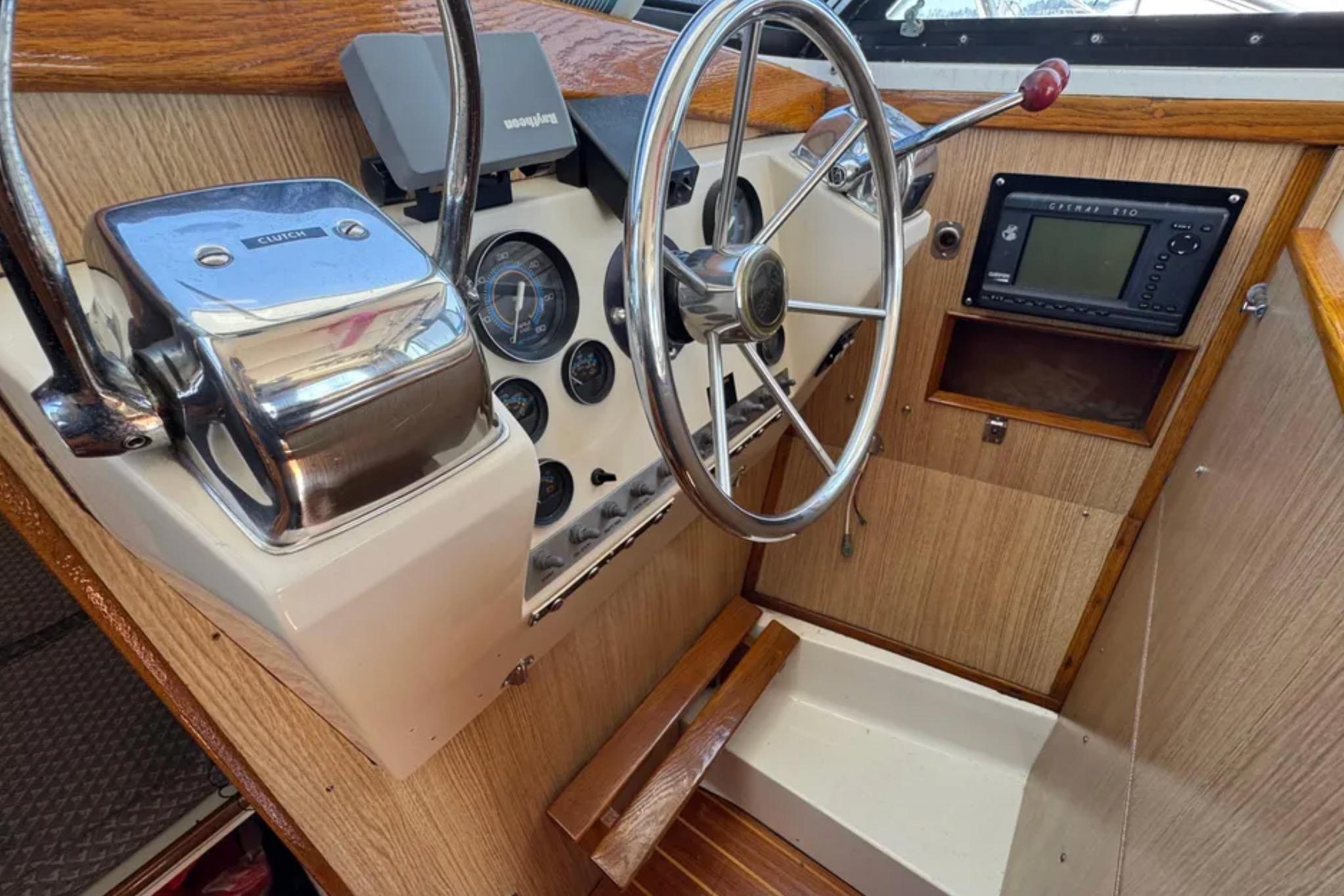 1988 Bertram 28 Sport Fisherman helm with steering wheel, gauges, and navigation equipment.