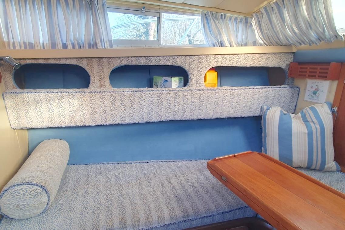 Cozy interior of 1989 Fairey Spearfish MKIII with blue and white striped cushions.