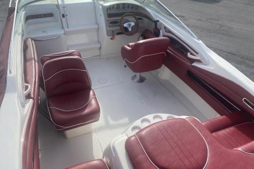 1997 Sea Ray 230 Overnighter boat interior with red and white seating and steering console.