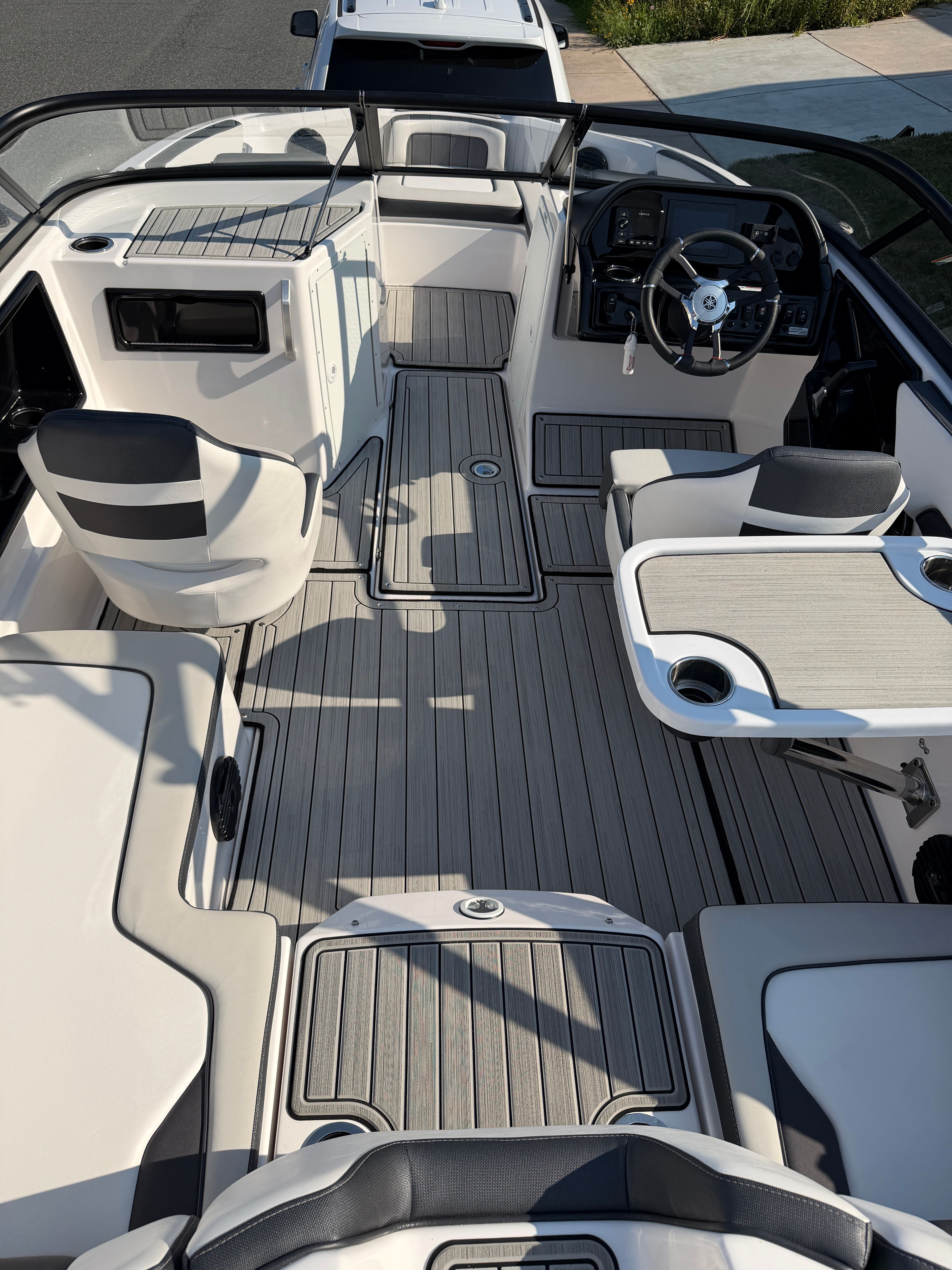 The image shows the cockpit of a 2023 Yamaha Boats 195S with modern seating and a sleek helm.
