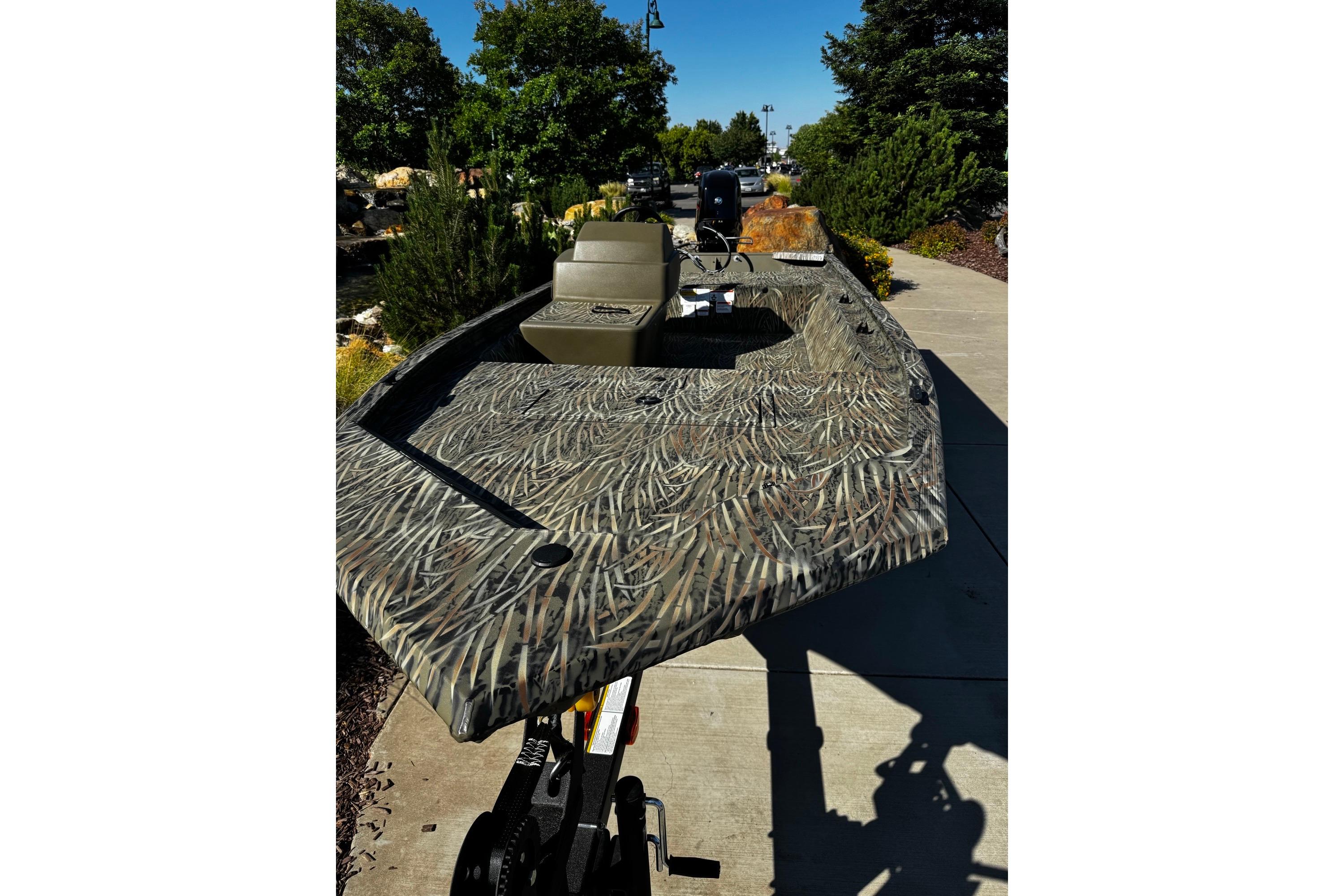2026 Tracker Grizzly 1648 SC boat with camouflage design on a sunny day.