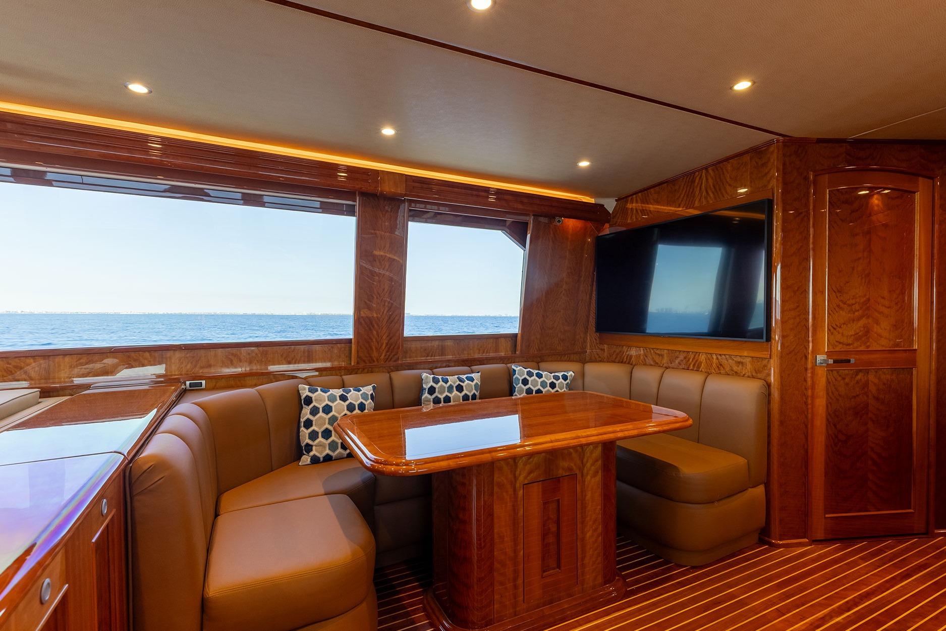 Luxurious interior of 2016 Viking 82 Sky Bridge yacht with ocean view and elegant wood finishes.