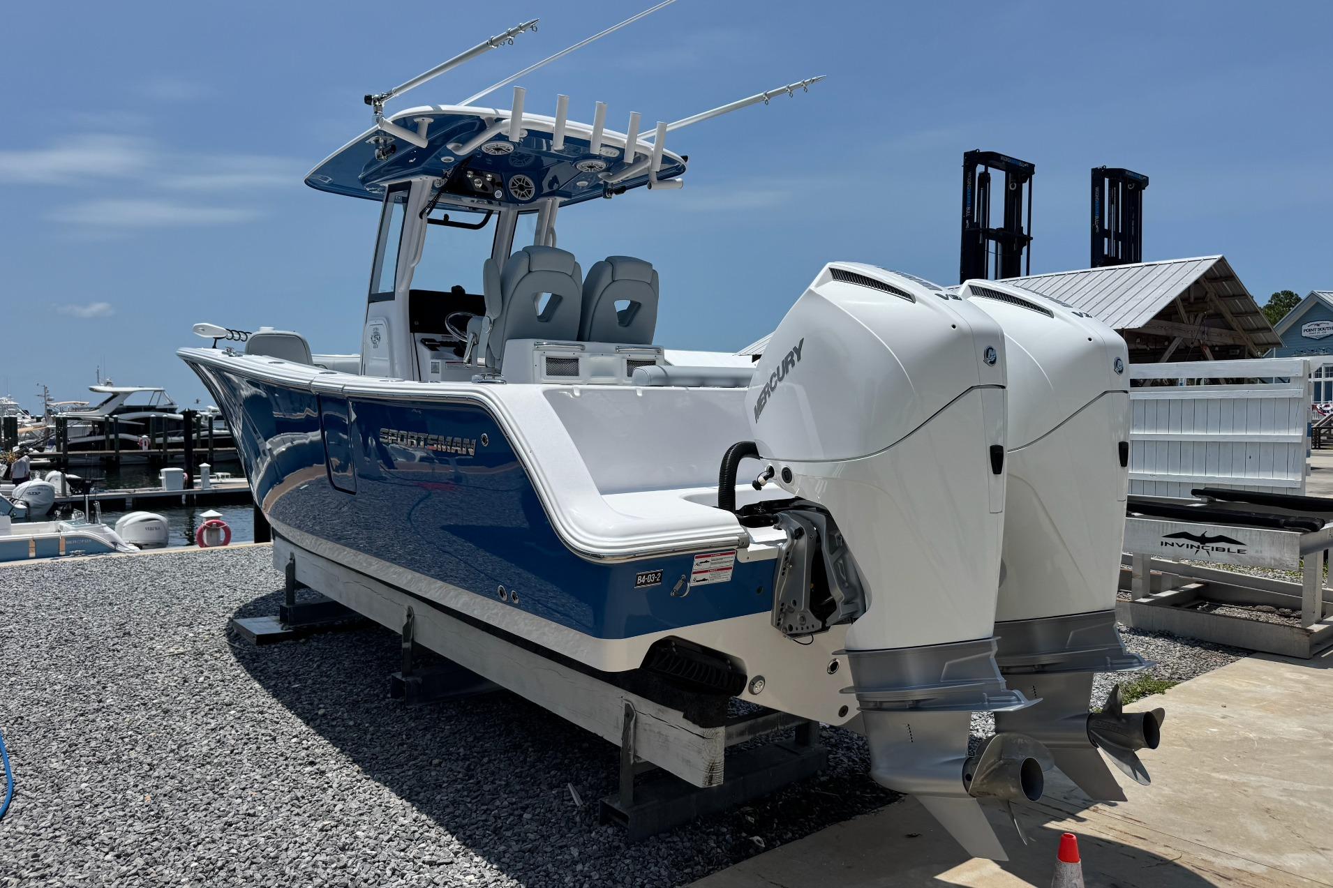 2026 Sportsman Open 262 Center Console boat with dual Mercury engines at a marina.