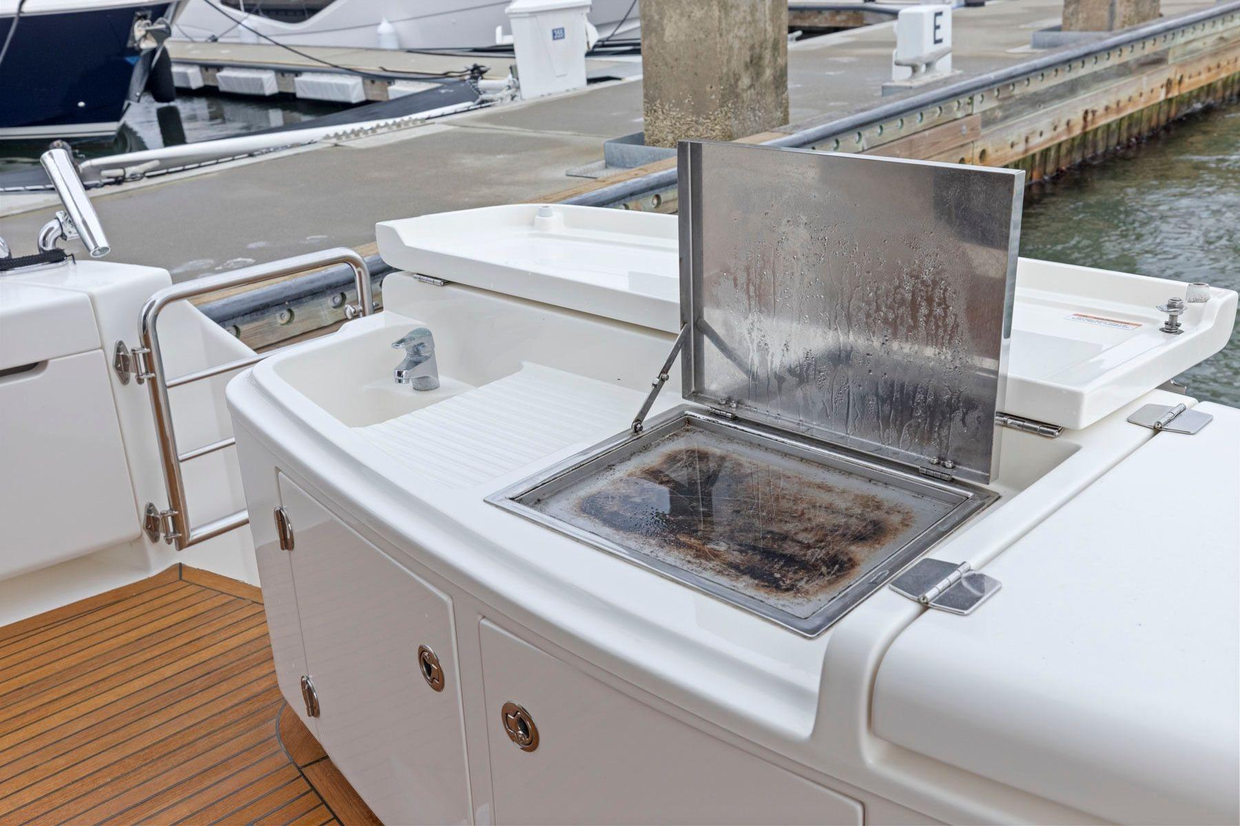 2014 Maritimo M50 yacht with outdoor sink and grill at marina.