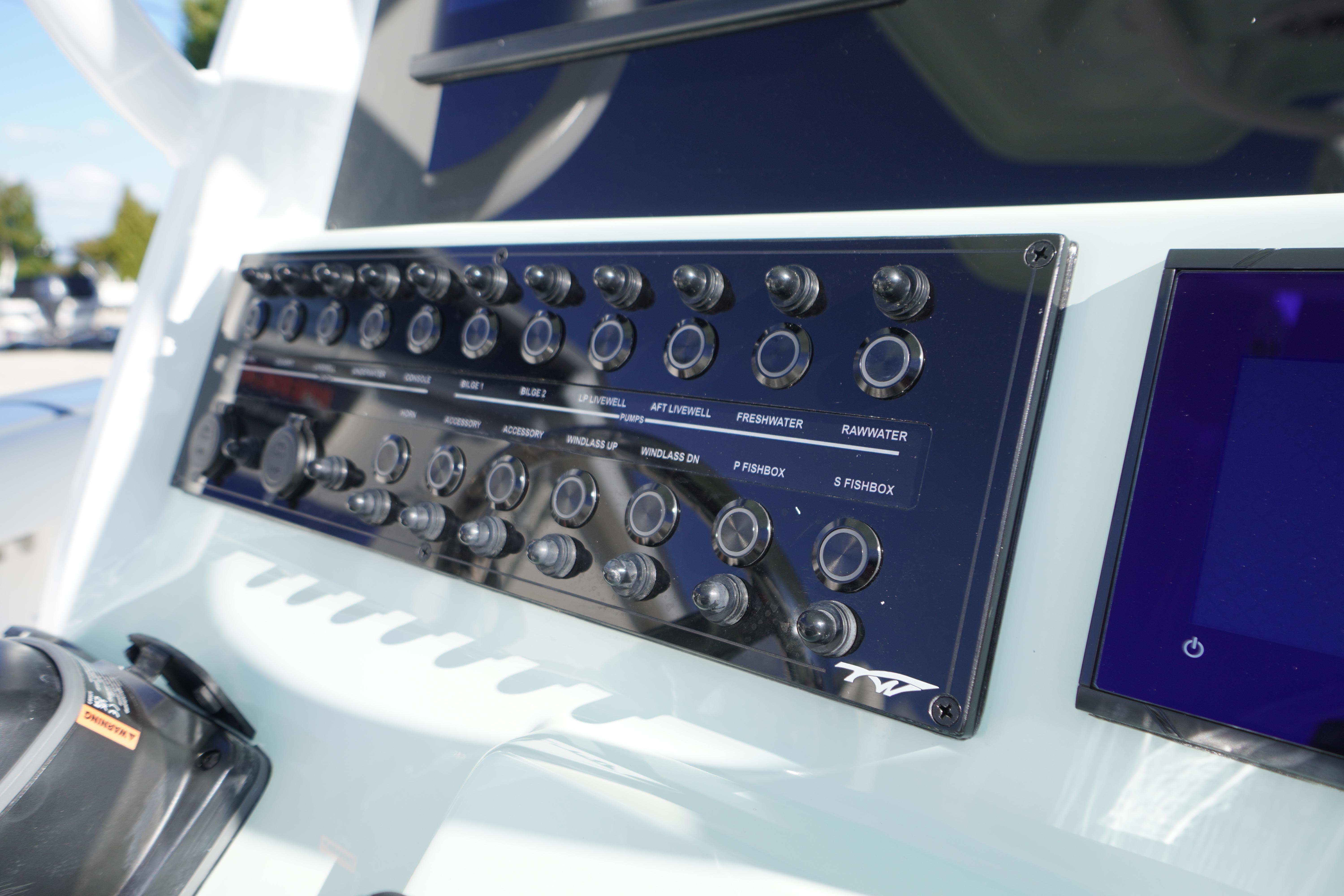 Control panel of 2026 Tidewater 272 LXF boat with various switches and buttons.