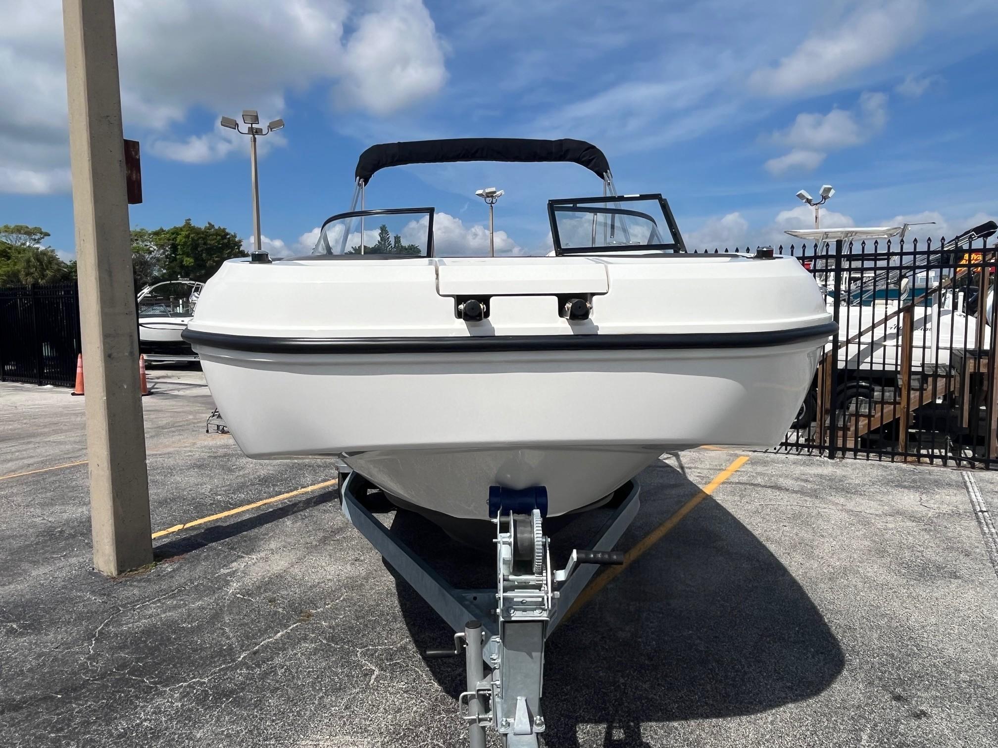 2022 Bayliner DX 2200 boat on trailer under a clear blue sky.