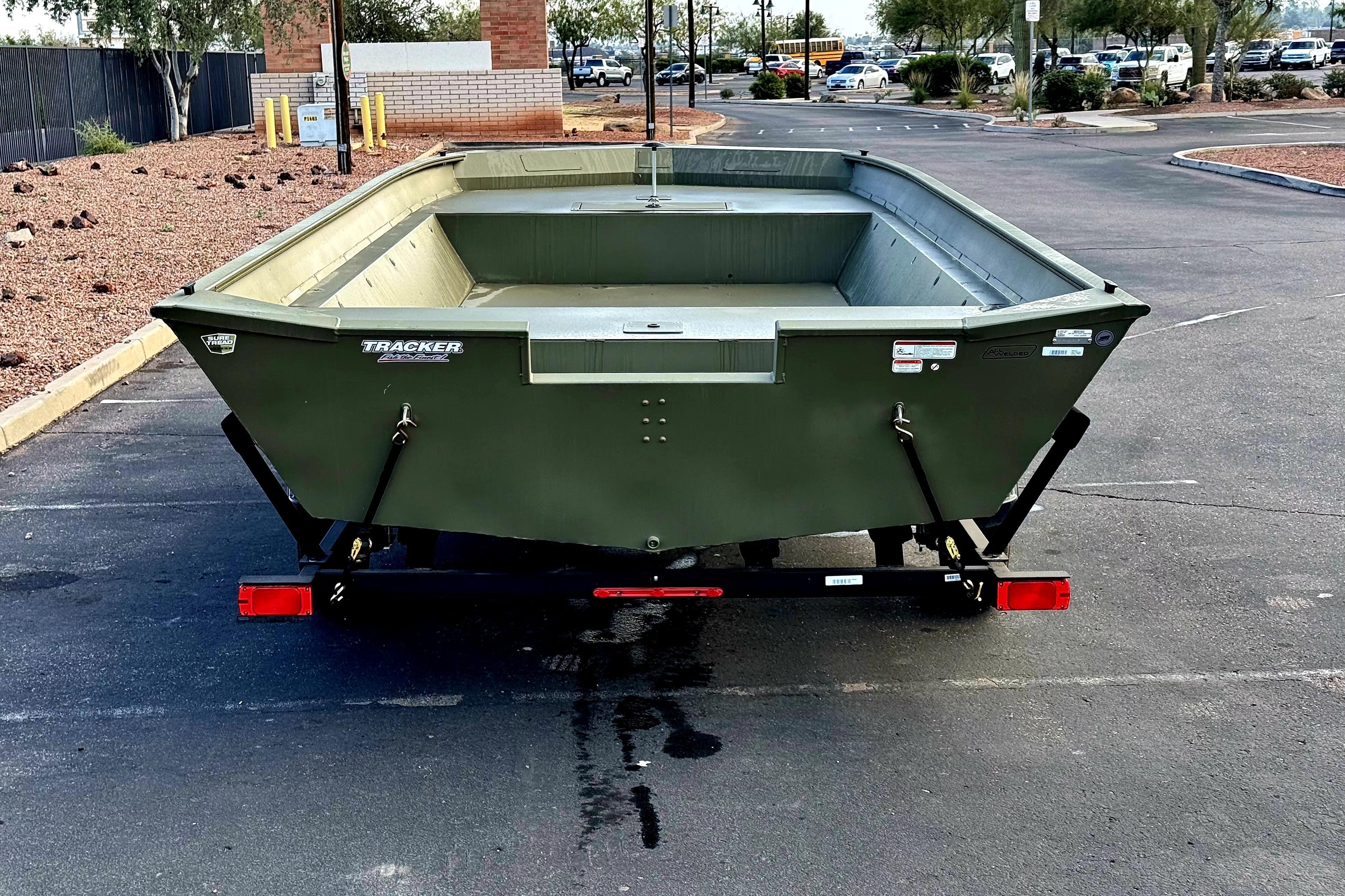 2026 Tracker Grizzly 2072 Utility boat on trailer in parking lot.