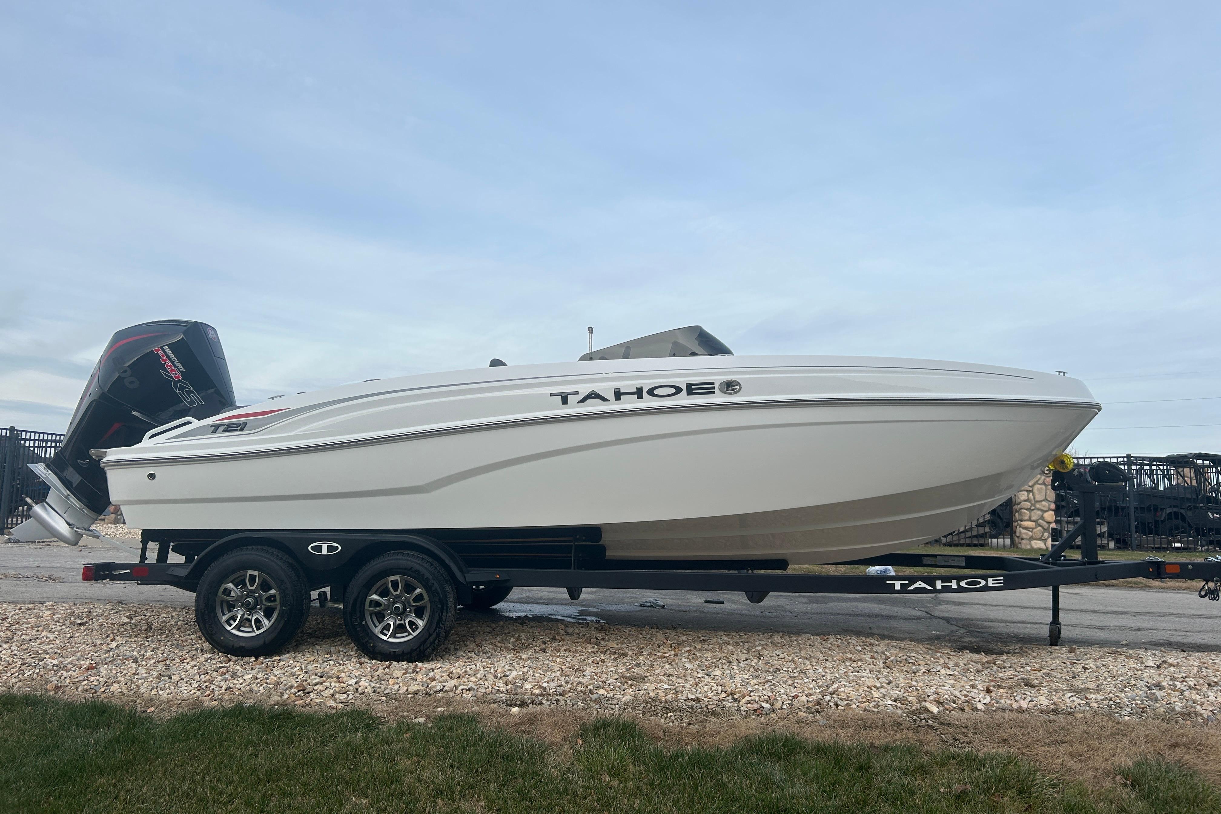 2025 Tahoe T21 boat on trailer, side view, outdoors.