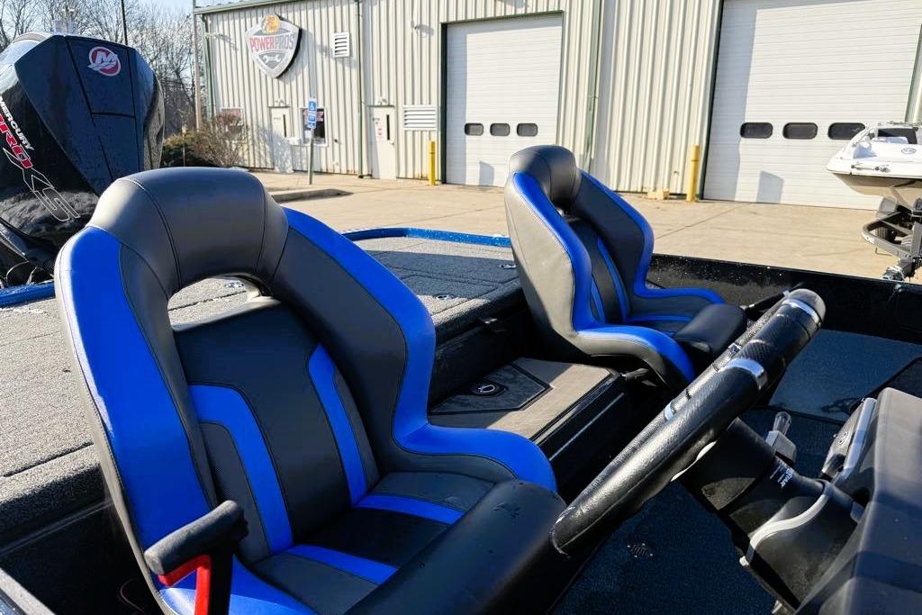 2026 Nitro Z20 XL Pro boat with blue and black seats, parked outside a garage.