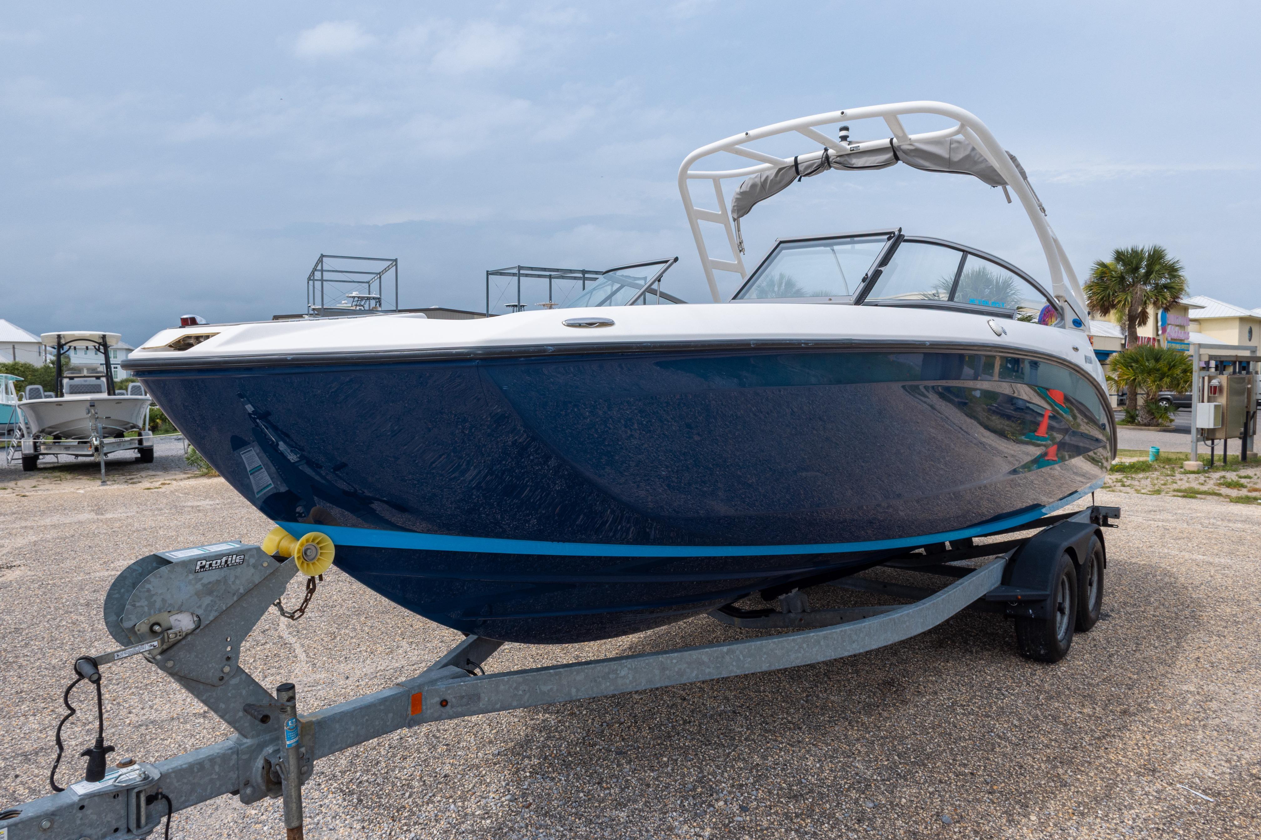 2021 Yamaha Boats AR250 on trailer, sleek design, blue hull, parked outdoors.
