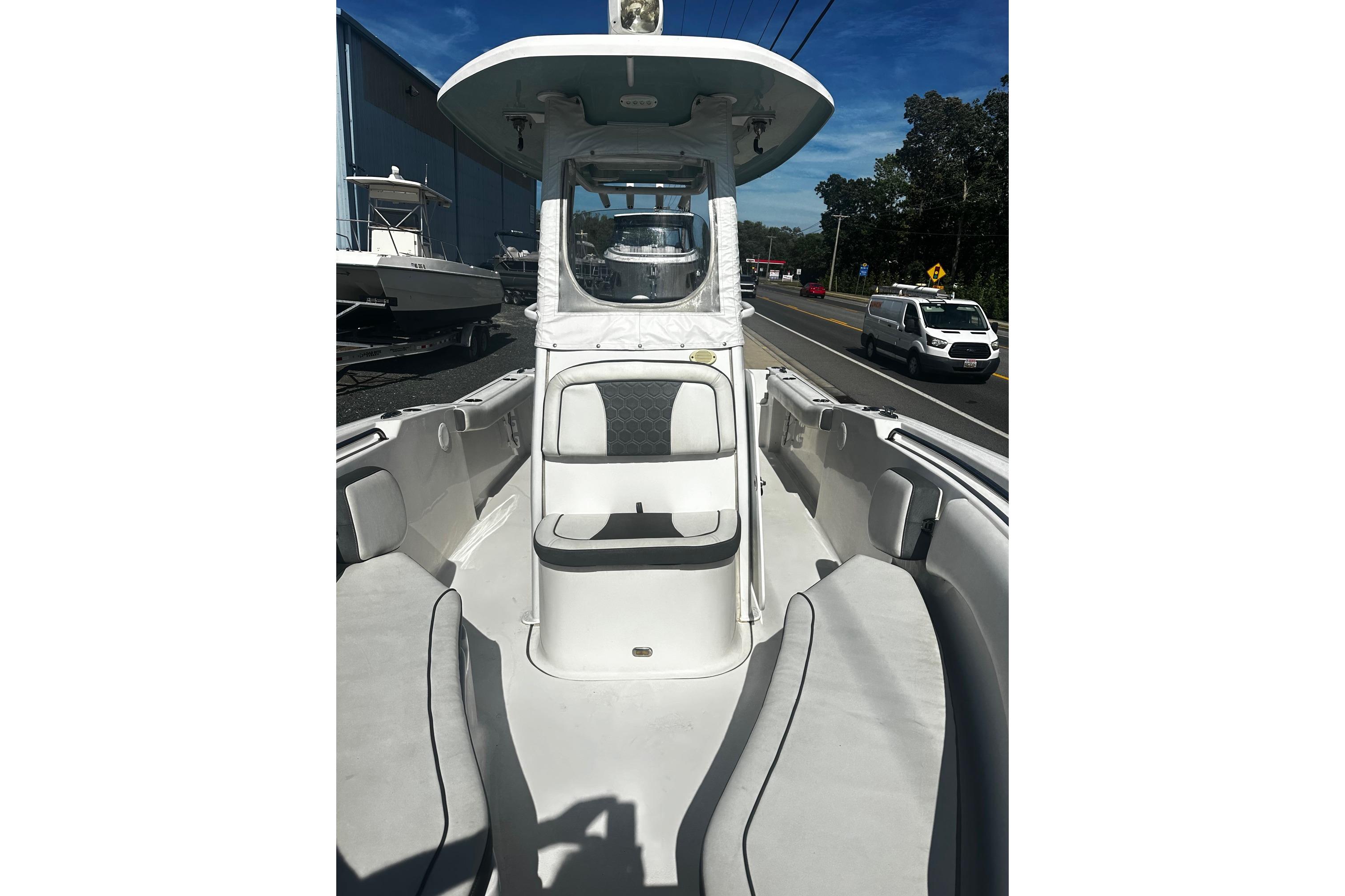 2020 Tidewater 230 CC Adventure boat interior with seating and console, parked near a road.