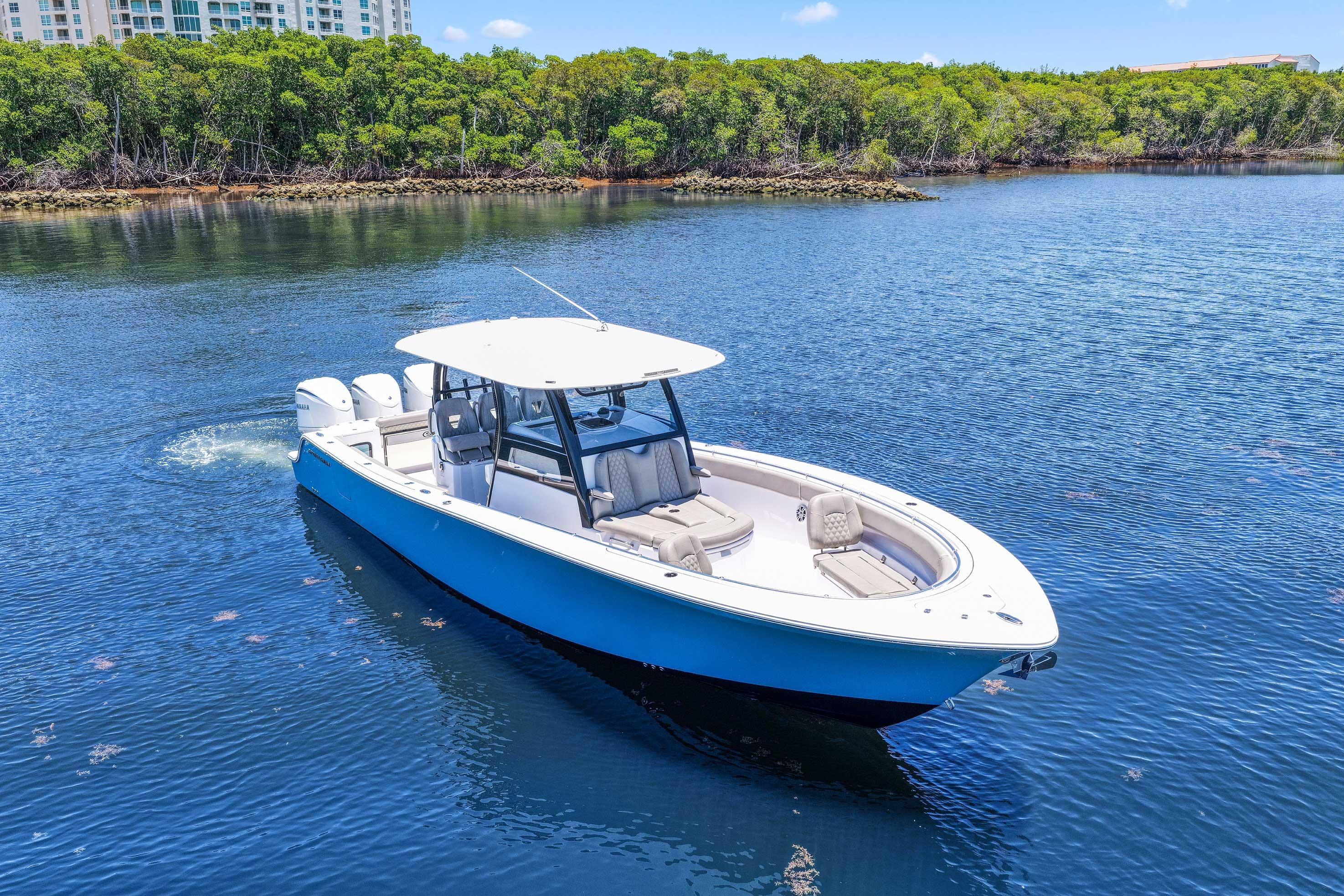 2024 Sportsman Open 352 Center Console boat on calm water, surrounded by lush greenery.