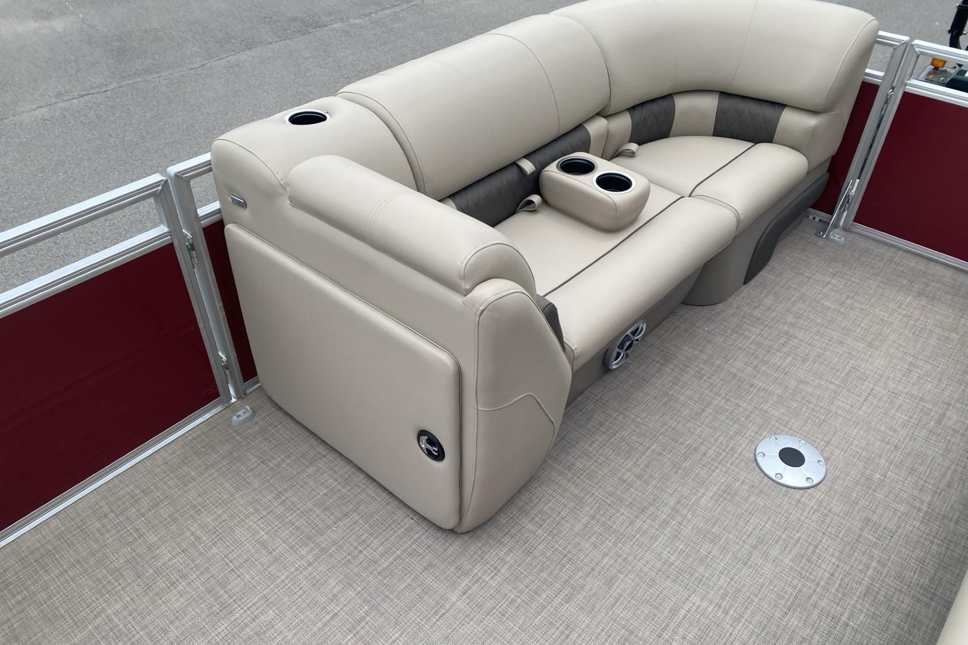 2024 Sun Tracker Party Barge 22 DLX interior with beige seating and cup holders.