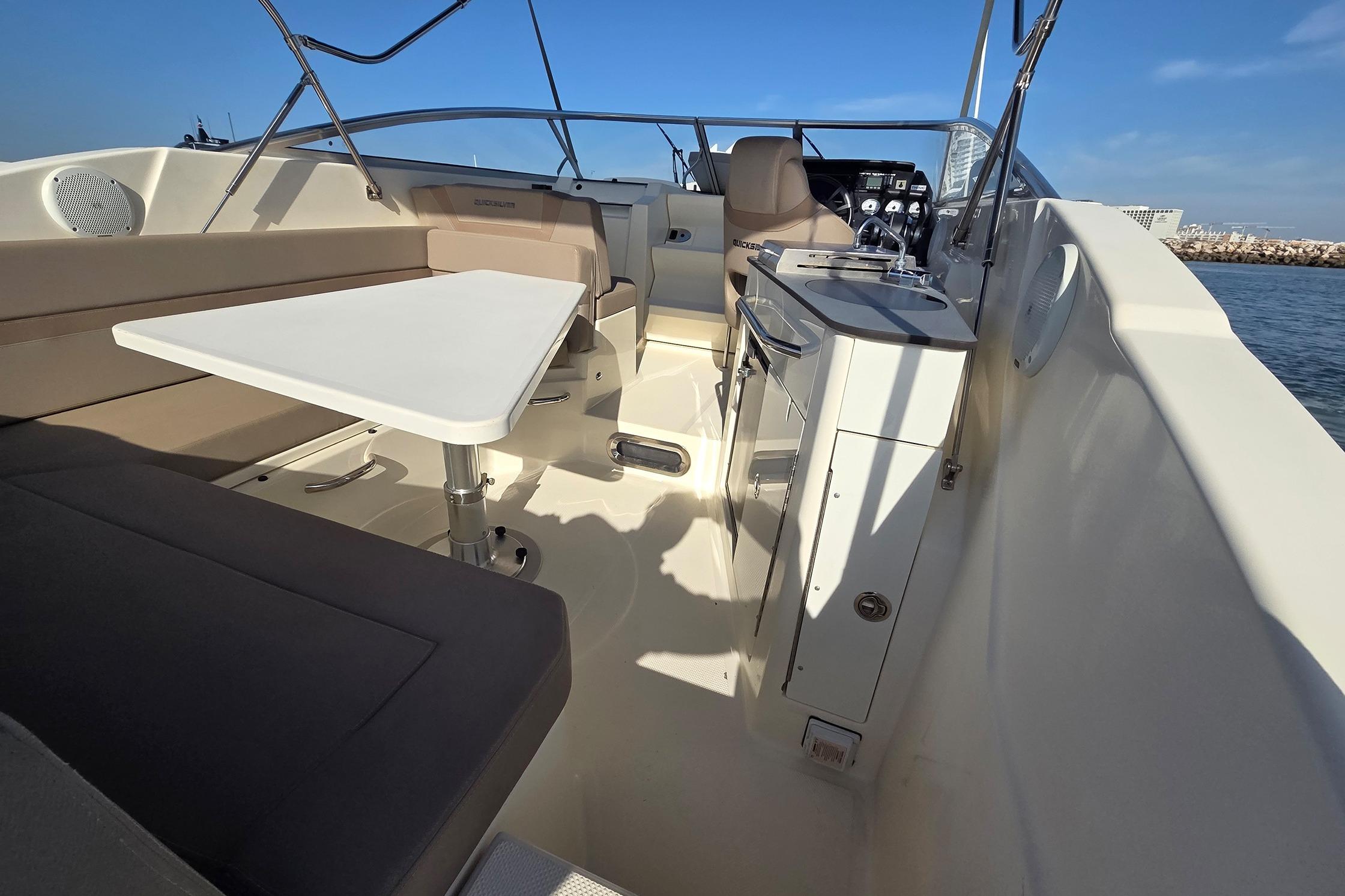 2017 Quicksilver Activ 805 Cruiser interior with seating, table, and helm.