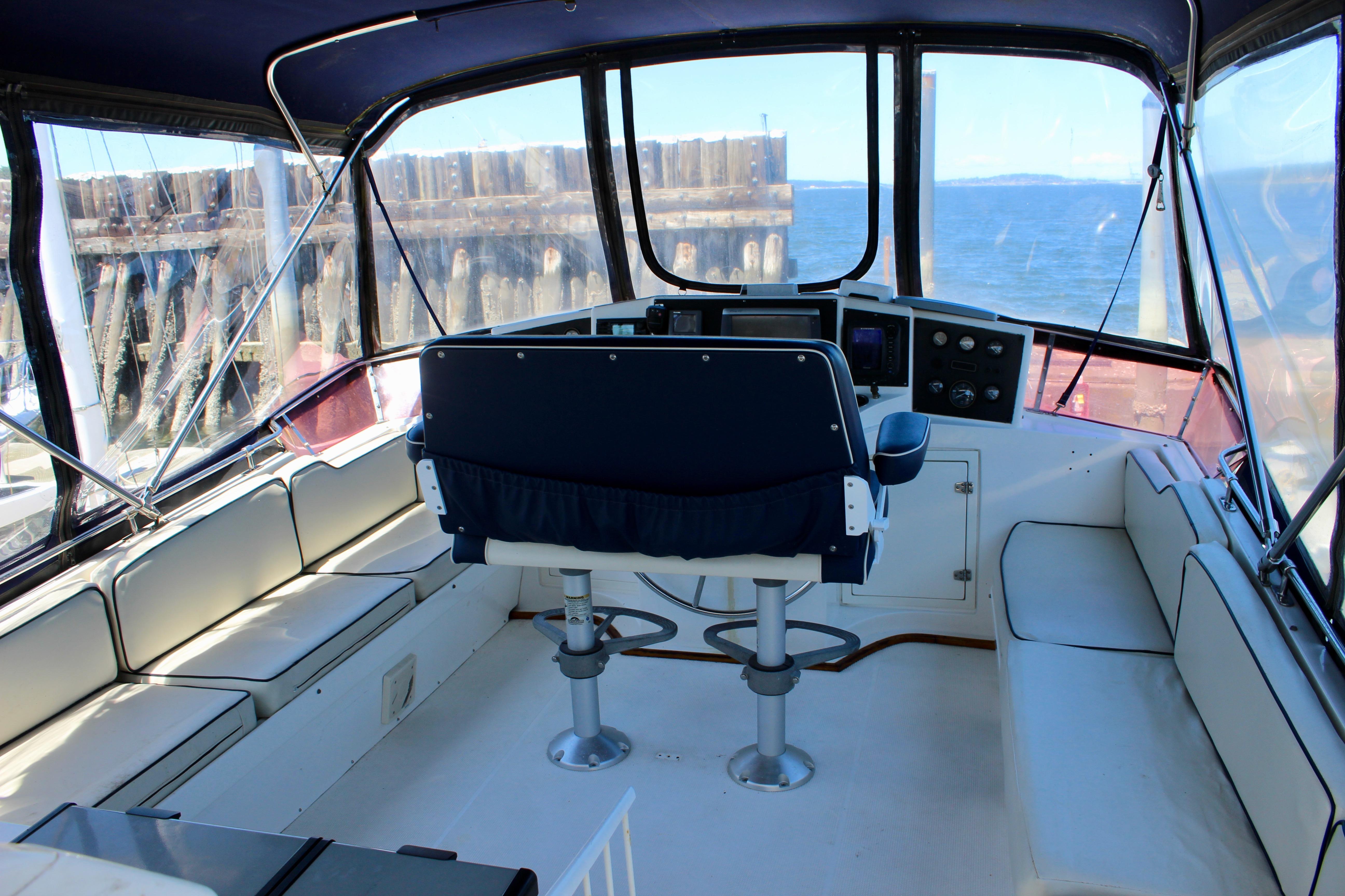 Interior view of 1986 Kha Shing Spindrift 46 yacht helm with seating and ocean backdrop.