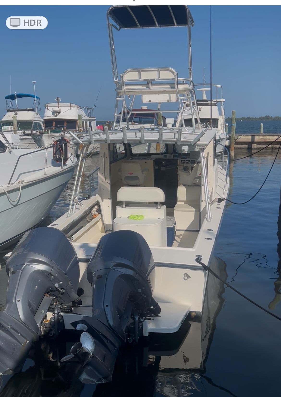 A 2009 May-Craft 2700 Pilot XL with twin outboard engines docked in a marina.