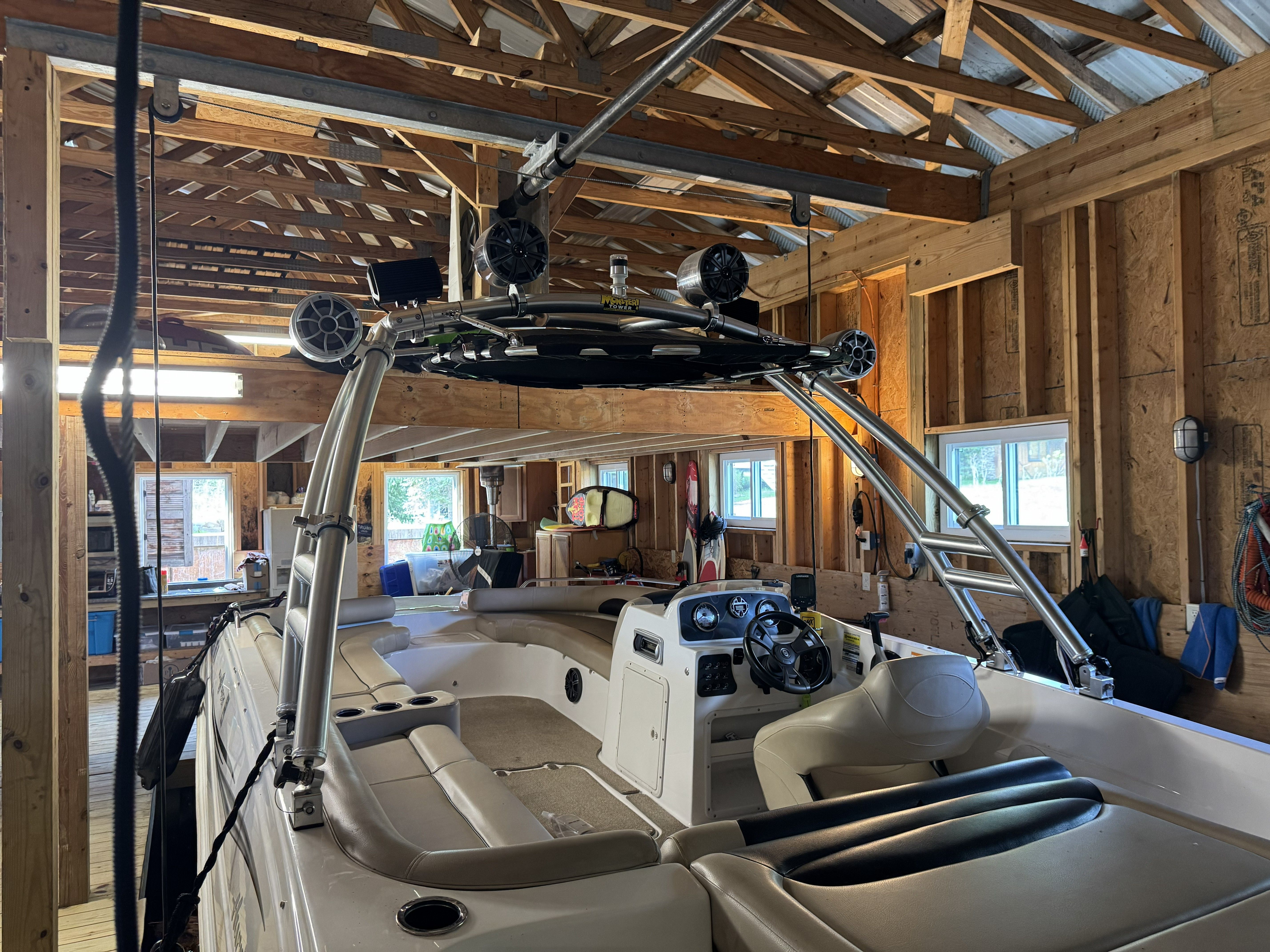 Interior view of a Hurricane SS201 I/O boat inside a wooden shed.