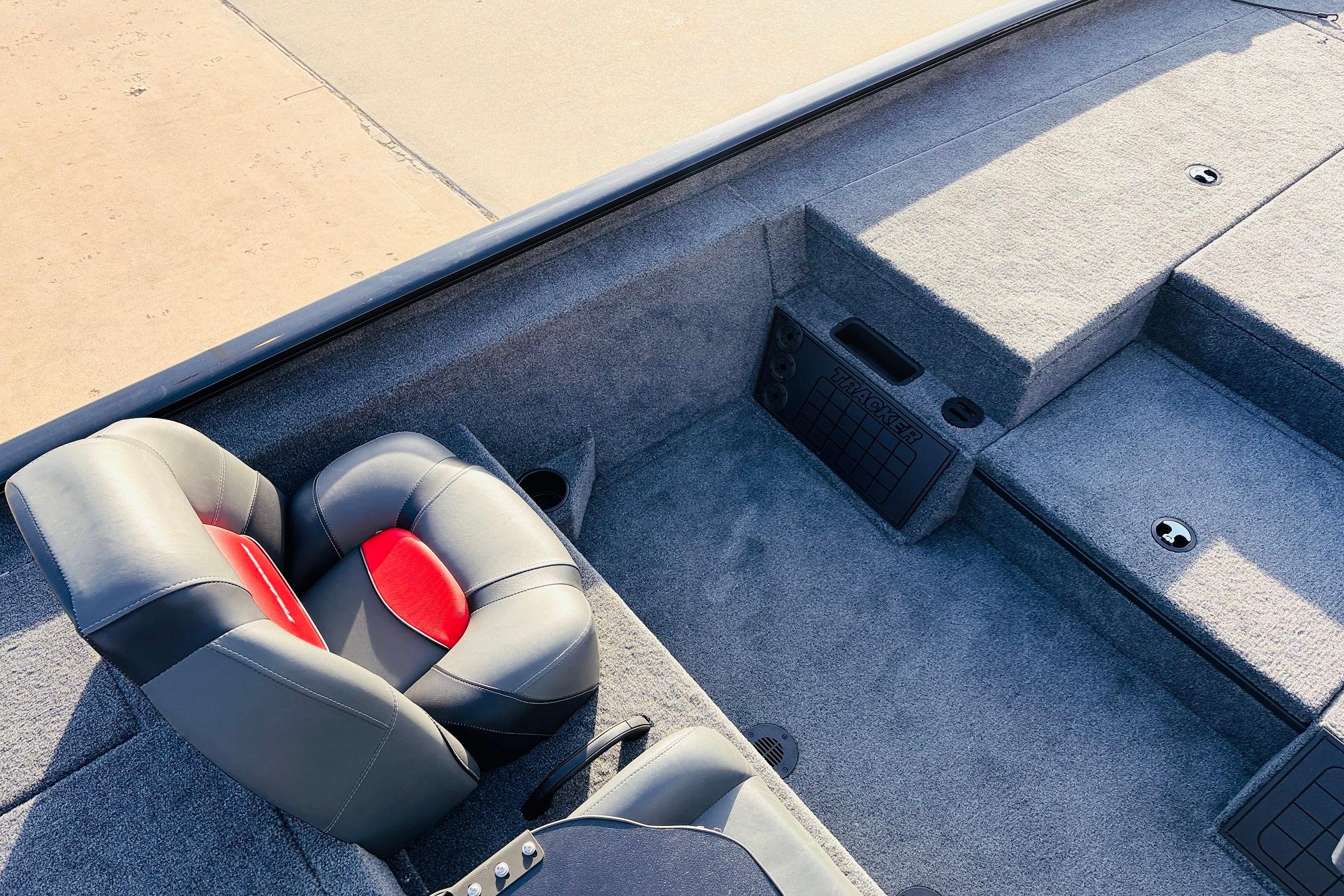 2025 Tracker Savage 215 boat interior with gray carpet and black-red seating.